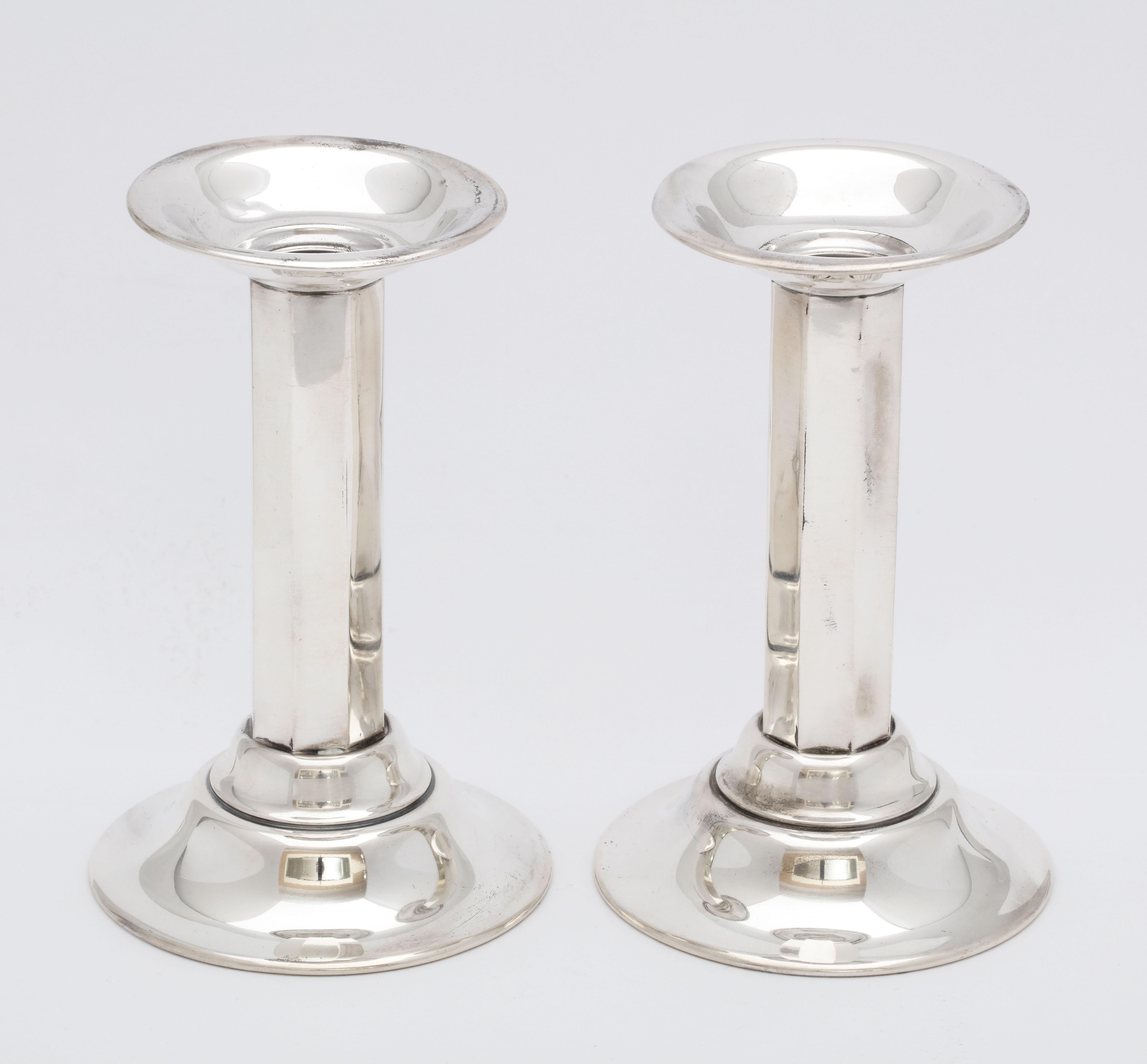 Pair of sterling silver, neoclassical, style, column-form candlesticks, Whiting Mfg. Co., Providence, Rhode Island, year-hallmarked for 1919. Faceted column. Each candlestick measures 5 inches high x 3 1/4 inches in diameter across base. Unweighted.