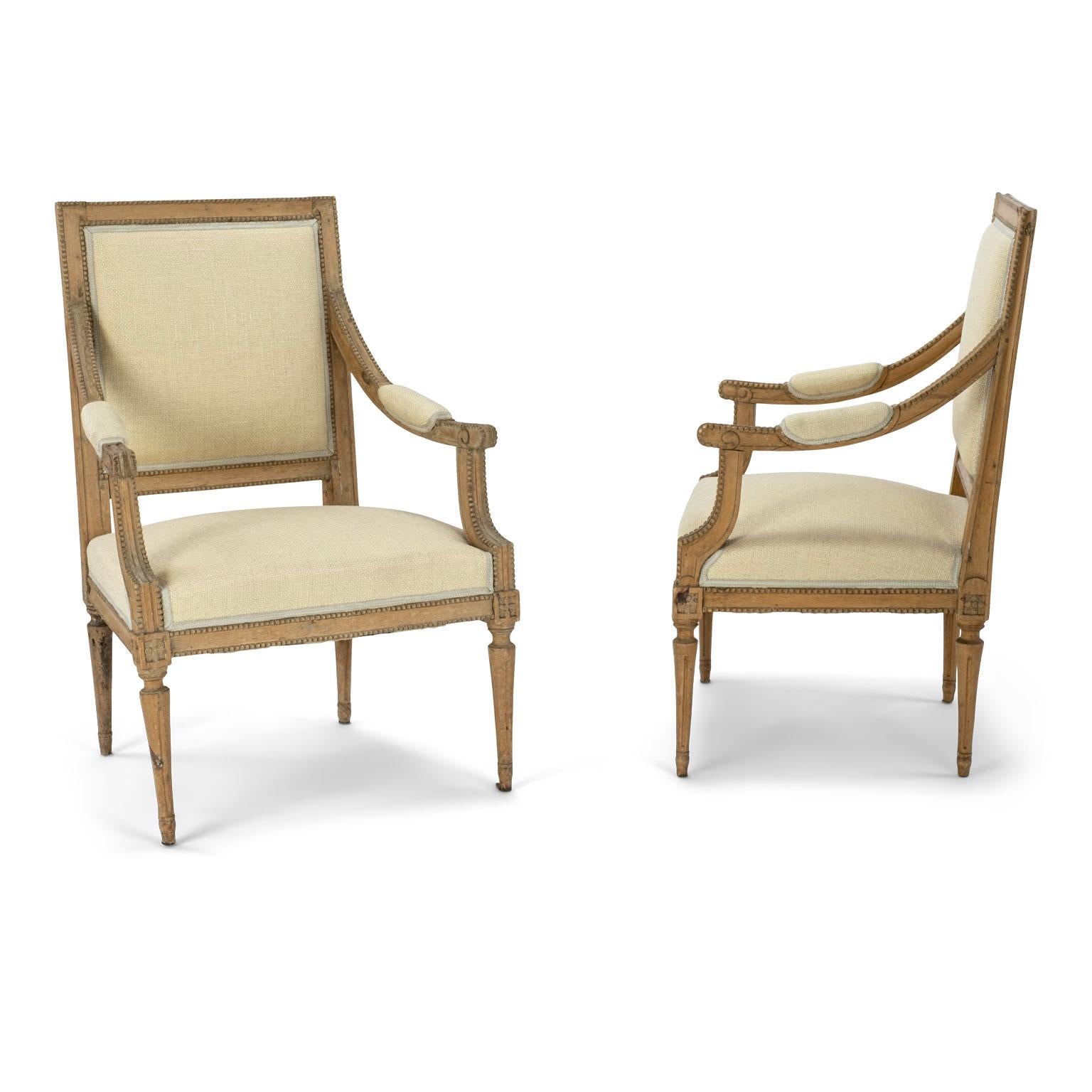 Pair of neoclassical Swedish armchairs constructed in beech circa 1840-1860. Upholstered in pale yellow-cream color linen. Excellent hand-carved beaded details. Sold together and priced $7,900 for the pair.