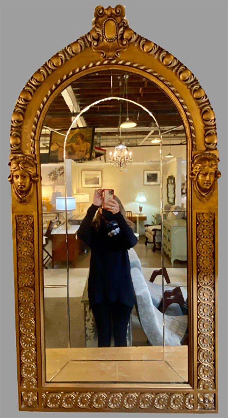Pair of neoclassical wall or console mirrors. Giltwood pair of Italian wall or console mirrors each having a clear center dome shaped mirror set inside a grouping of smaller mirrors flanked by a carved giltwood frame having female heads on each