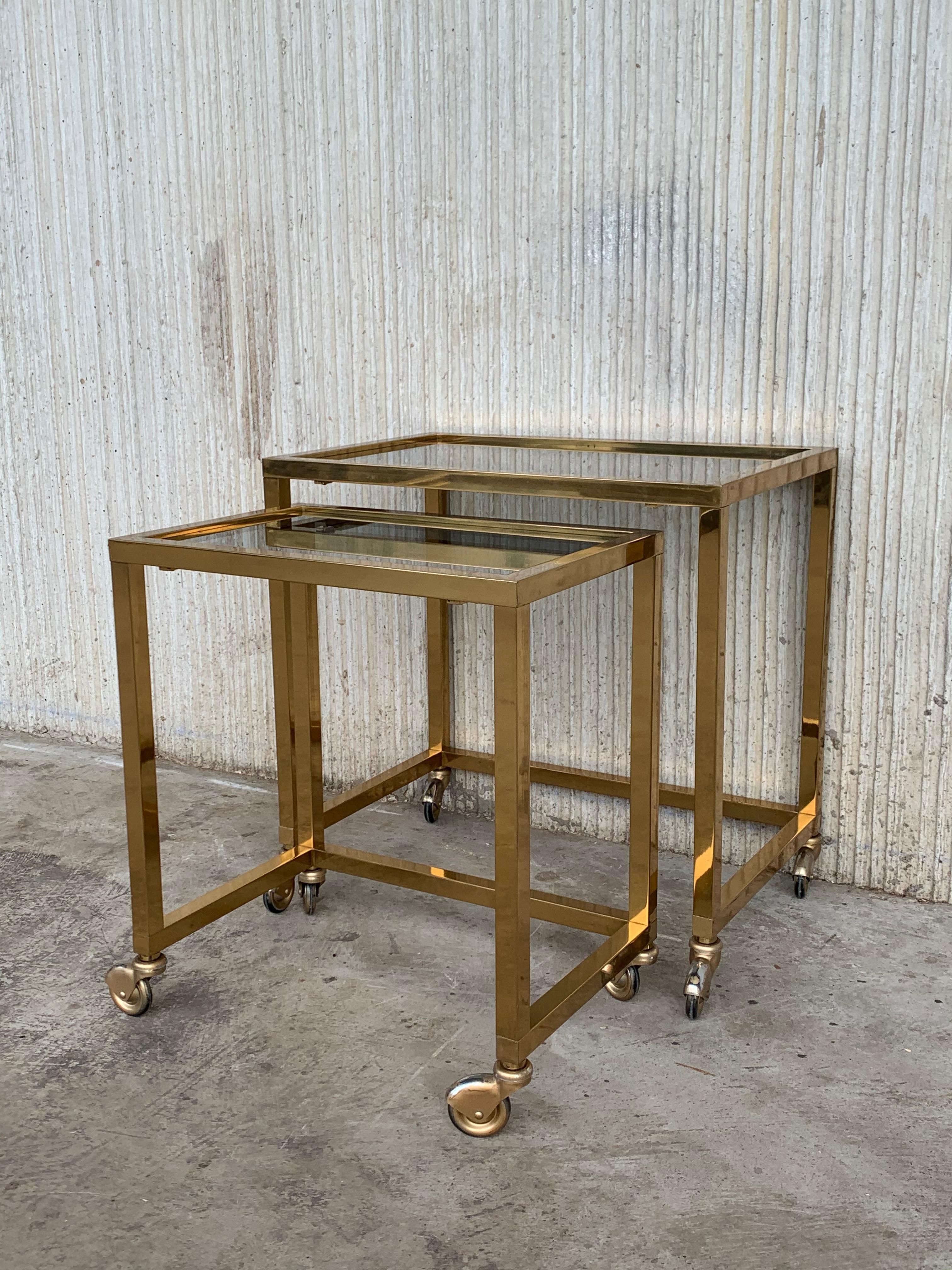 Pair of Italians nesting tables, brass in original patina and glasses in perfect conditions, they are on wheels.

Measures: Large W 19.68in, D 13in, H 19.68in
Small W 15.75in, D 10.63in, H 17.9in.