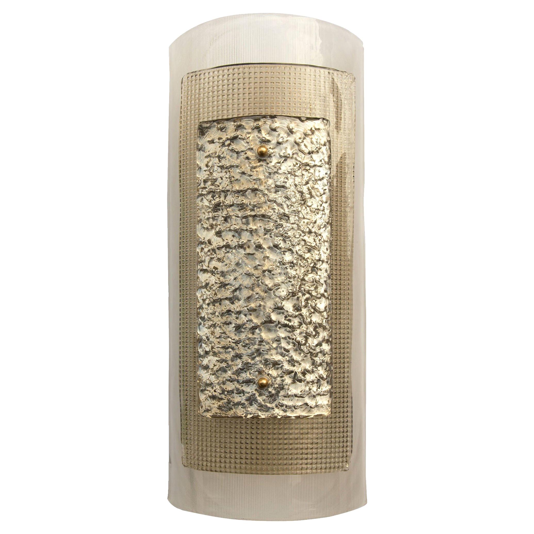 Hand blown Murano glass wall light. Three textured curved glass pieces form this wall light with a simple bass fixing on the front face. Back glass plate is light smoke color glass with a very Fine rib texture to the reverse. Middle glass plate if