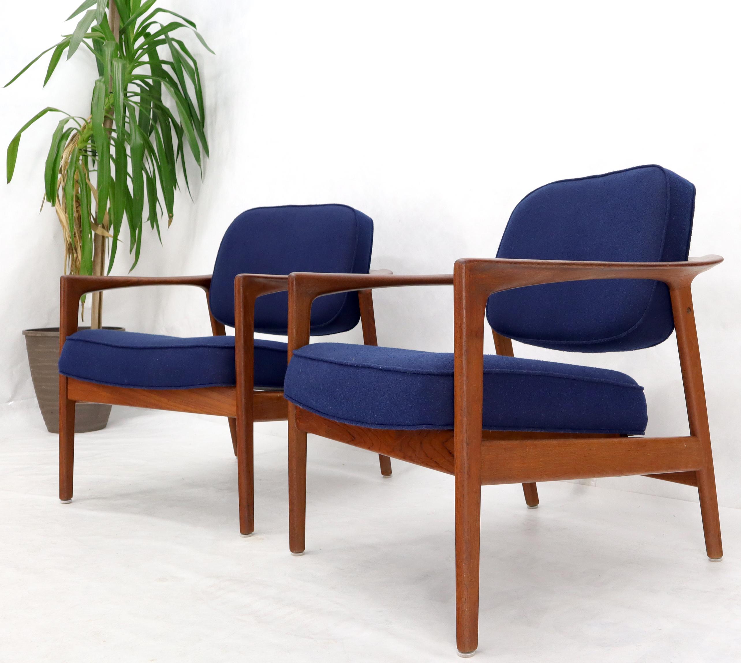 Pair of DUX Danish Modern teak lounge newly upholstery in navy blue fabric. Nice solid teak wrap around back connected arms similar to barrel back design.
