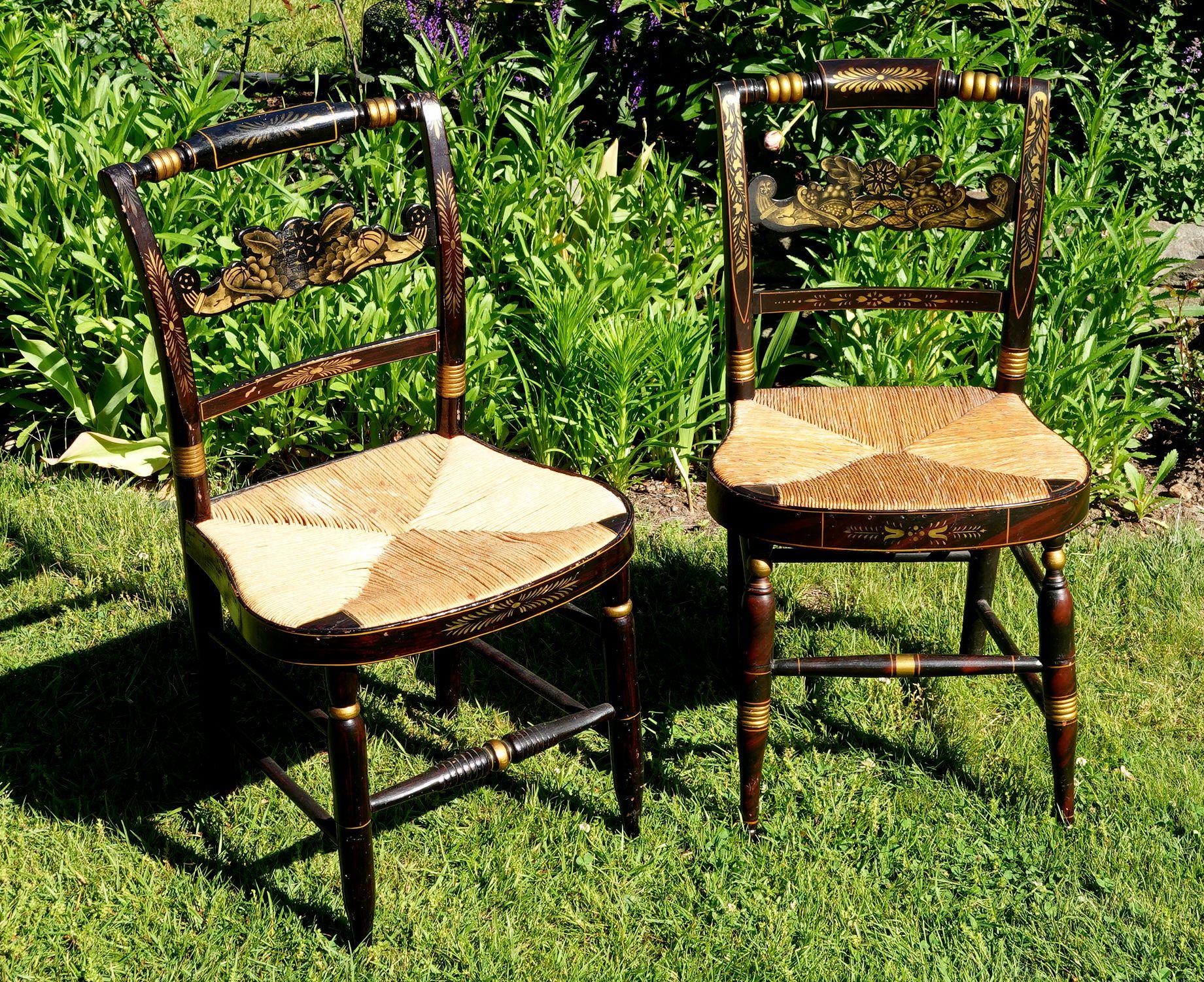 Pair of New England Hitchcock Style/Fancy chairs. Hand painted/stenciled with a deep and rich patination from years of good wear. The seats are woven rush seats and are in very good condition.

Width: 17 in (43.18 cm)
Depth: 15.25 in (38.74