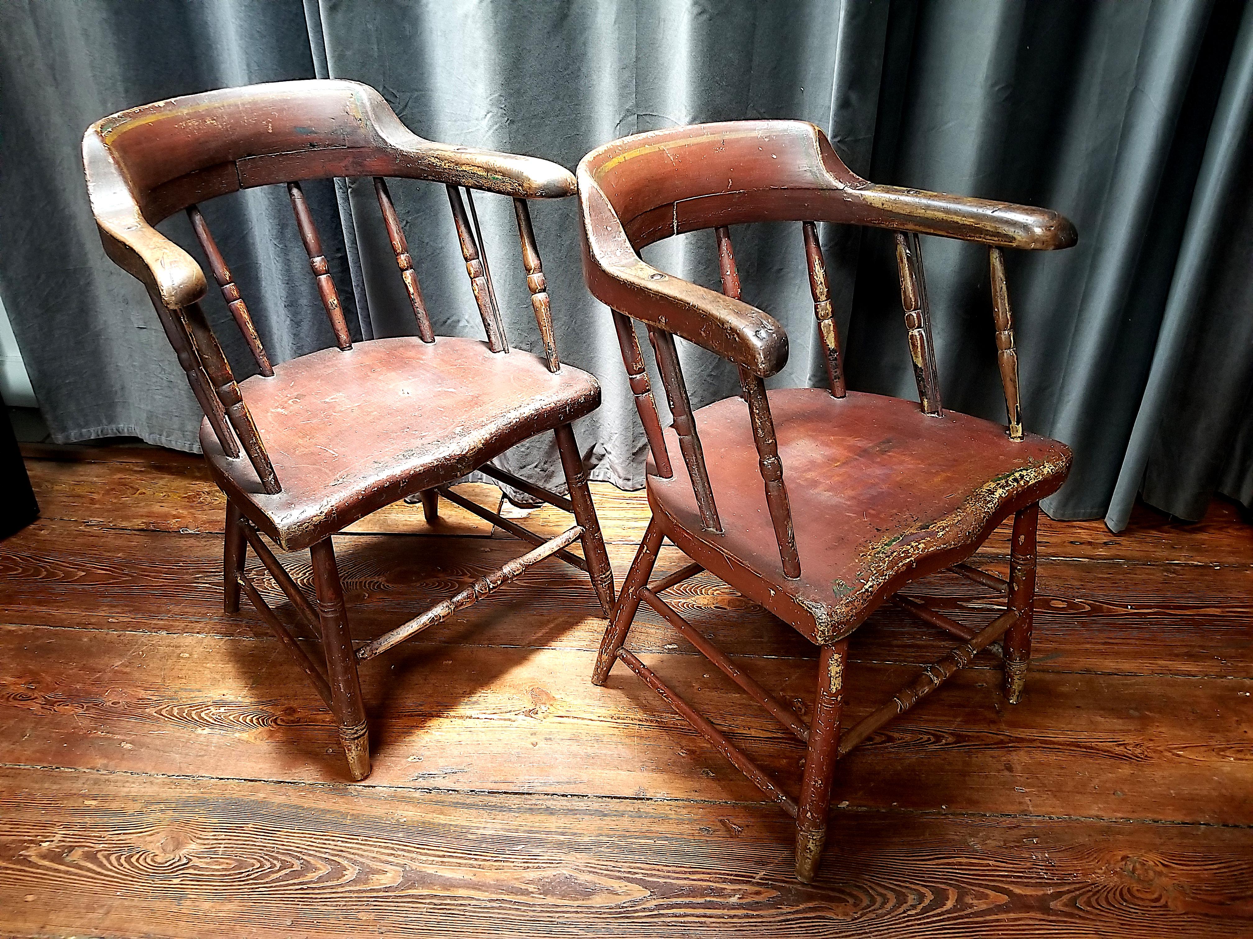Schönes und bequemes Paar Windsor-Stühle im Stil der Feuerwache oder des Kapitäns. 
Die originalen Eisenstreben, die lackierte Oberfläche und die reiche, warme Patina der Abnutzung sind erhalten. 
Neuengland, die Stühle wurden um 1820 gebaut und