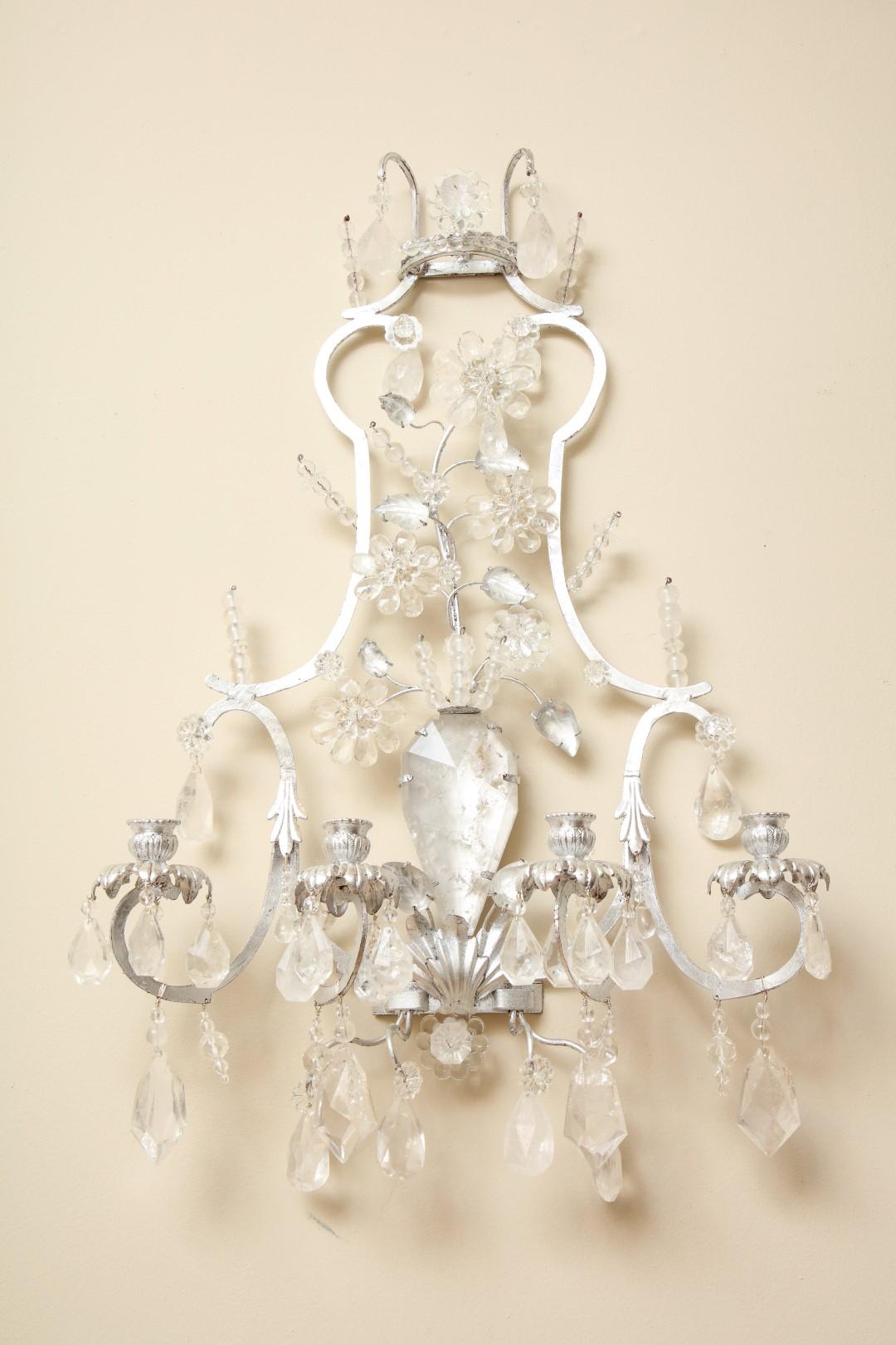 A pair of new silvered-metal four-light sconces, curved open work backplate centering a rock crystal vase and foliage, the candlearms with silvered bobeches suspending faceted rock crystal drops.
Price does not include UL wiring. 

 