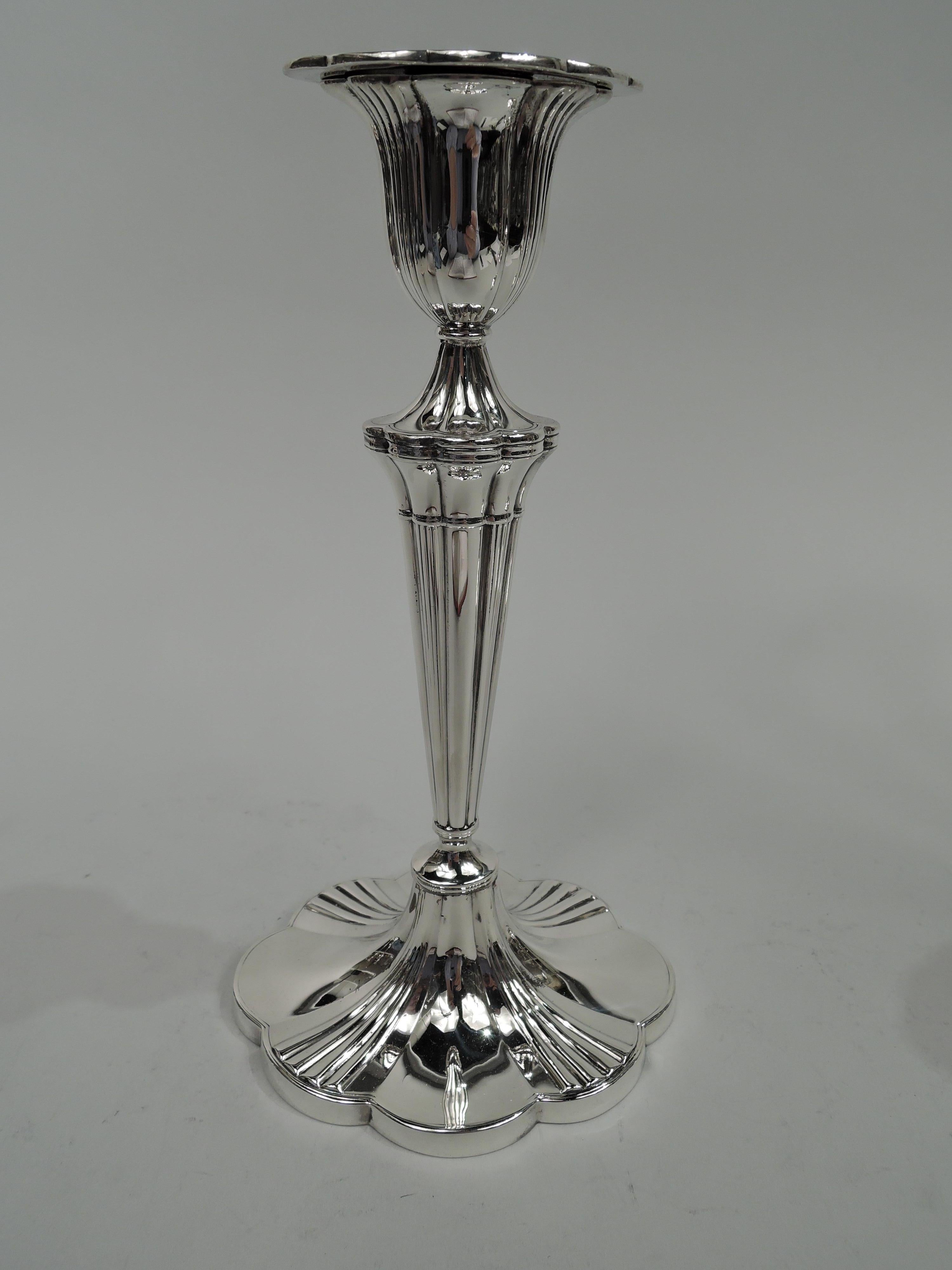 Pair of Modern sterling silver candlesticks. Made by Marcus & Co. in New York, circa 1920. Ovoid. Urn socket with detachable bobeche on raised support mounted to tapering shaft; raised foot. Alternating reeded and plain flutes. Scalloped rims. Fully