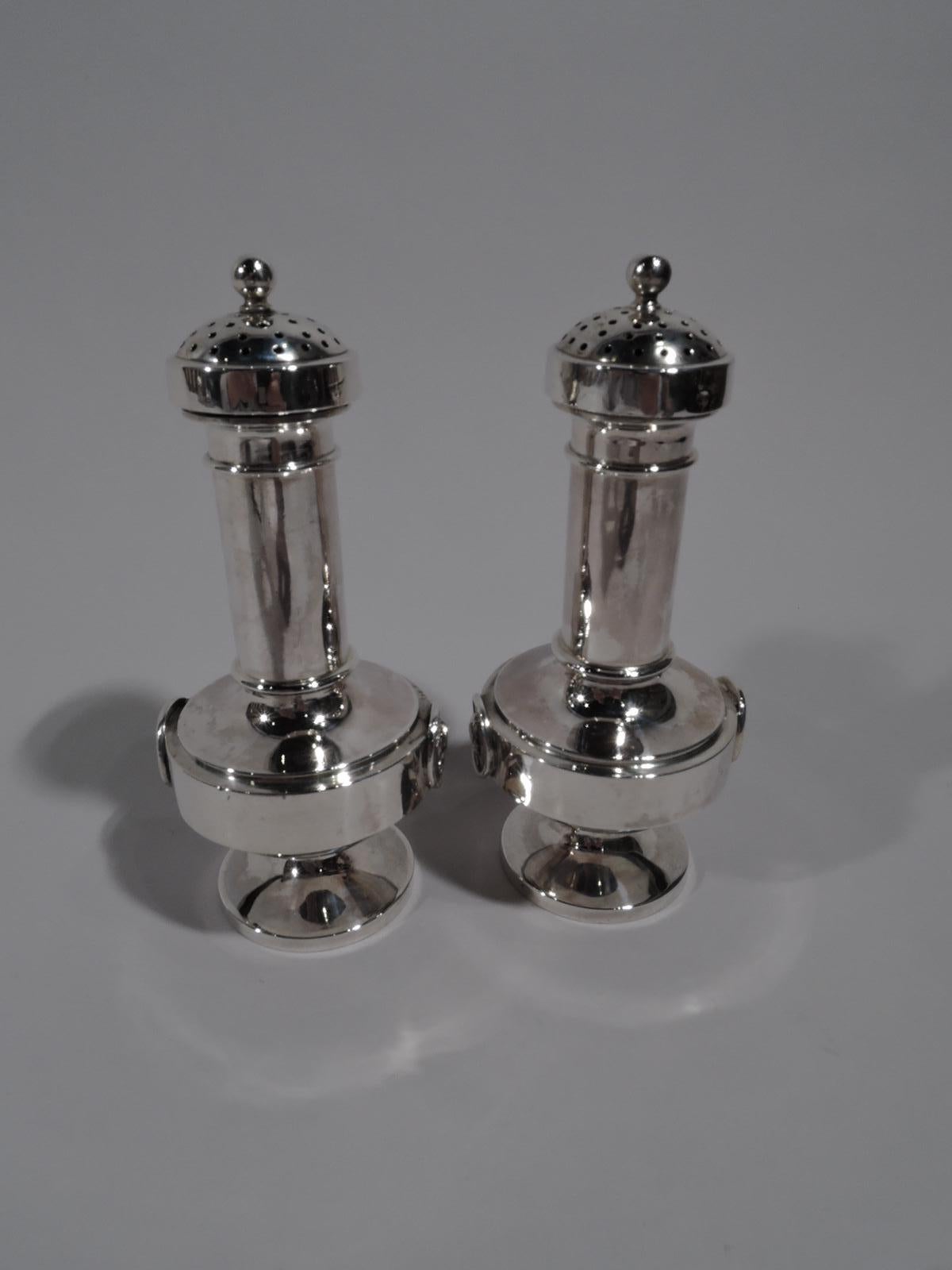 Pair of sterling silver Medallion salt and pepper shakers, circa 1870. Each: Cylindrical neck, bellied bowl, and round foot. Cover domed and overhanging with dense piercing. Two rondels with raised Classical head in profile on lined ground, one is a