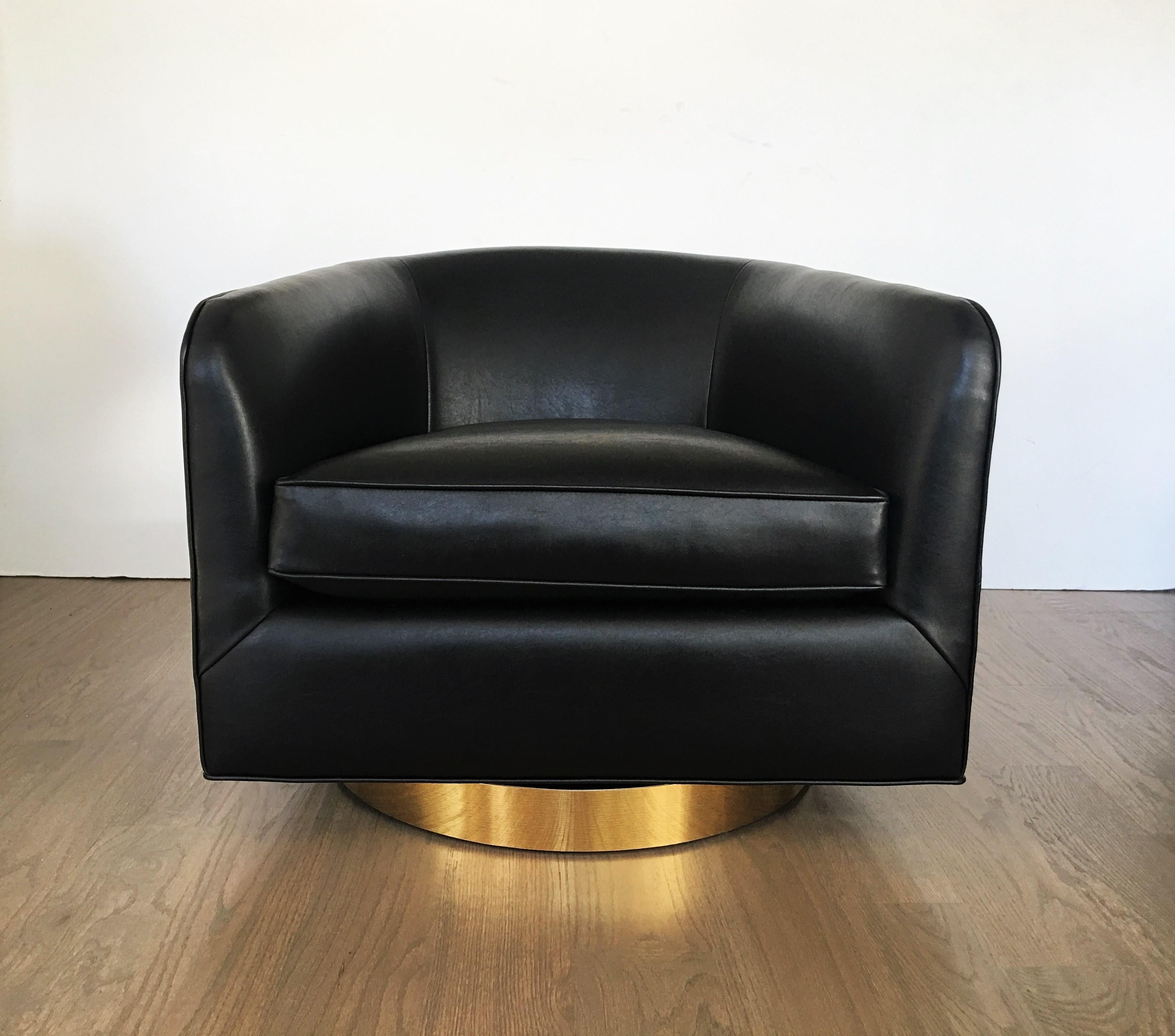 Clean lines and restrained, geometric form these gorgeous swivel chairs designed by Milo Baughman. Freshly restored these well-crafted chairs feature barrel shaped frames reupholstered in rich black upholstery on swivel brass plinths.