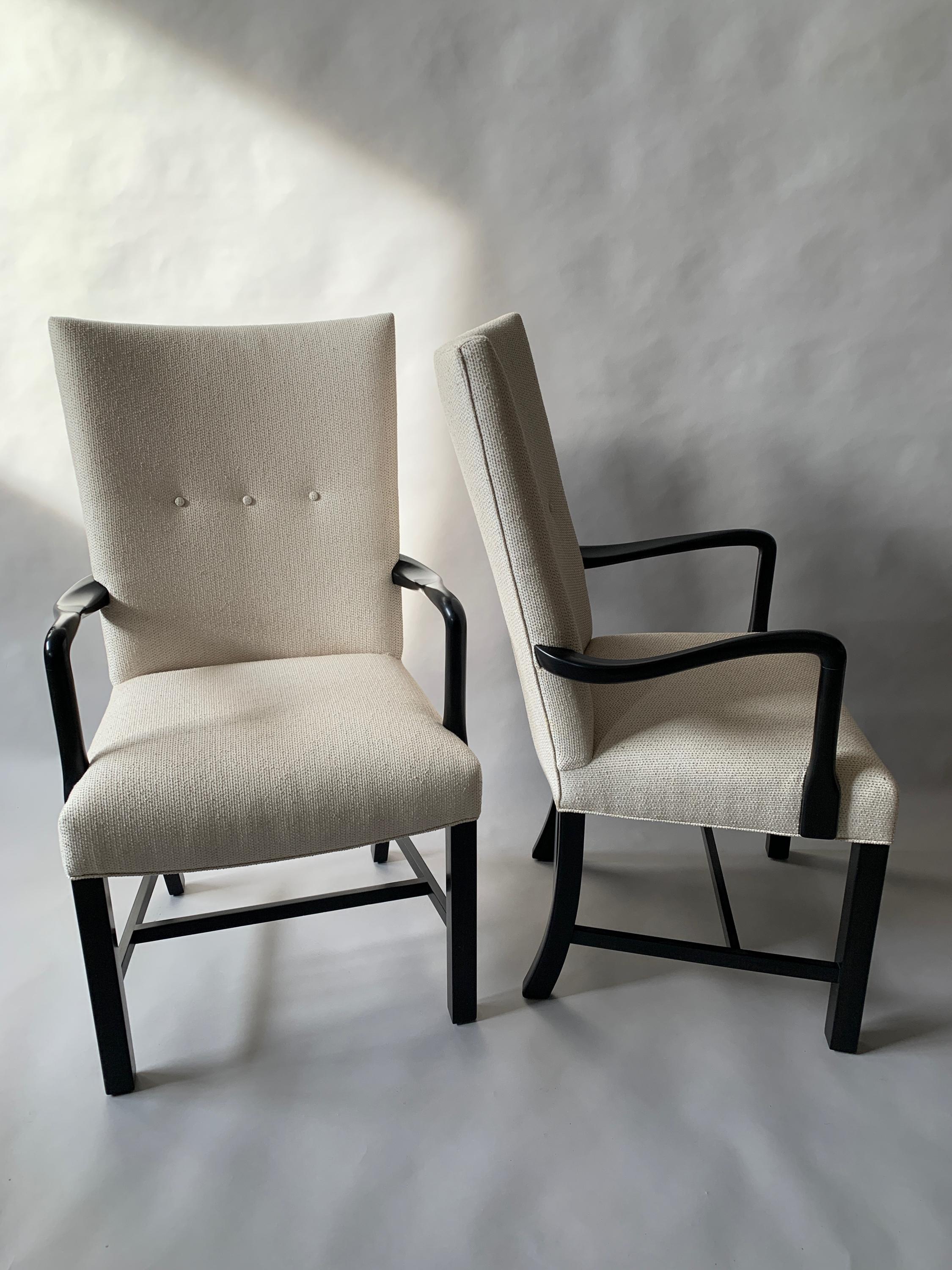 Pair of Danish 1940s ebonized armchairs/side chairs with curved arms. Newly upholstered in Sunbrella with button tufting to the back. 
Measure: Arm height - 27.5