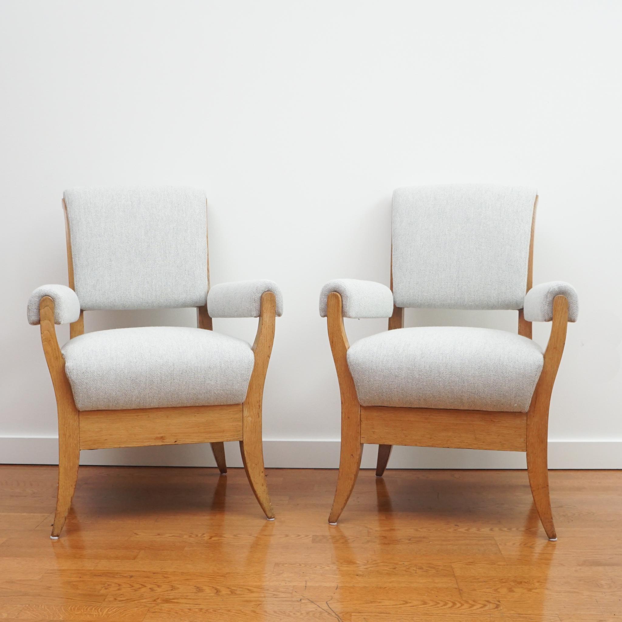 The splayed legs, upholstered arm rests and beefy wood frames of these oak armchairs from the 1940s contributes to their unique appeal. By replacing the original brown leather upholstery with a light-colored, woven fabric, the chairs now look fresh,