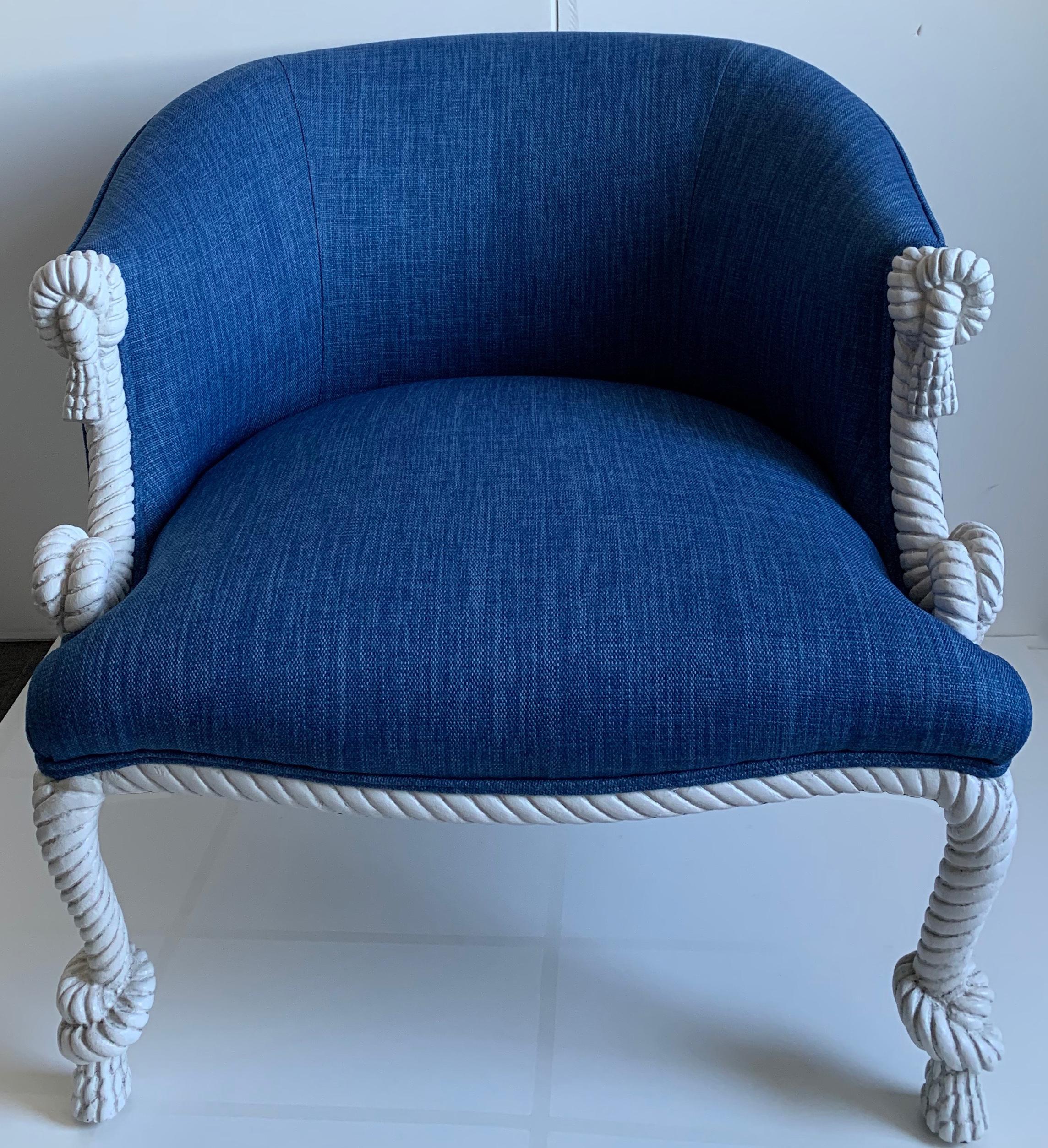 Pair of 1940s carved rope motif armchairs. Newly refinished in antique white painted finish. Chair frame is carved wood with simulated rope motif. Knot and tassel detailing at arms and feet. Curved back design. Newly upholstered in marine blue