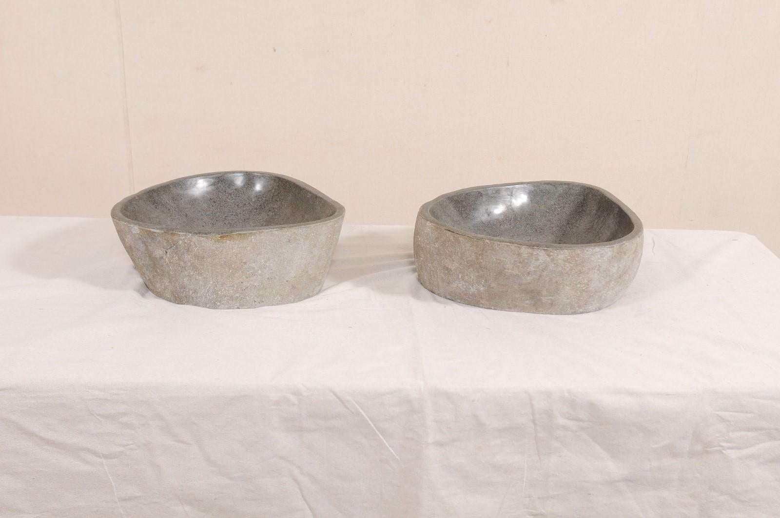A pair of river rock wash basins. This pair of sinks have each been carved from a single, natural river rock boulder. Each sink has a polished bowl with natural stone on the exterior. Beautifully organic designs courtesy of Mother Nature, no two