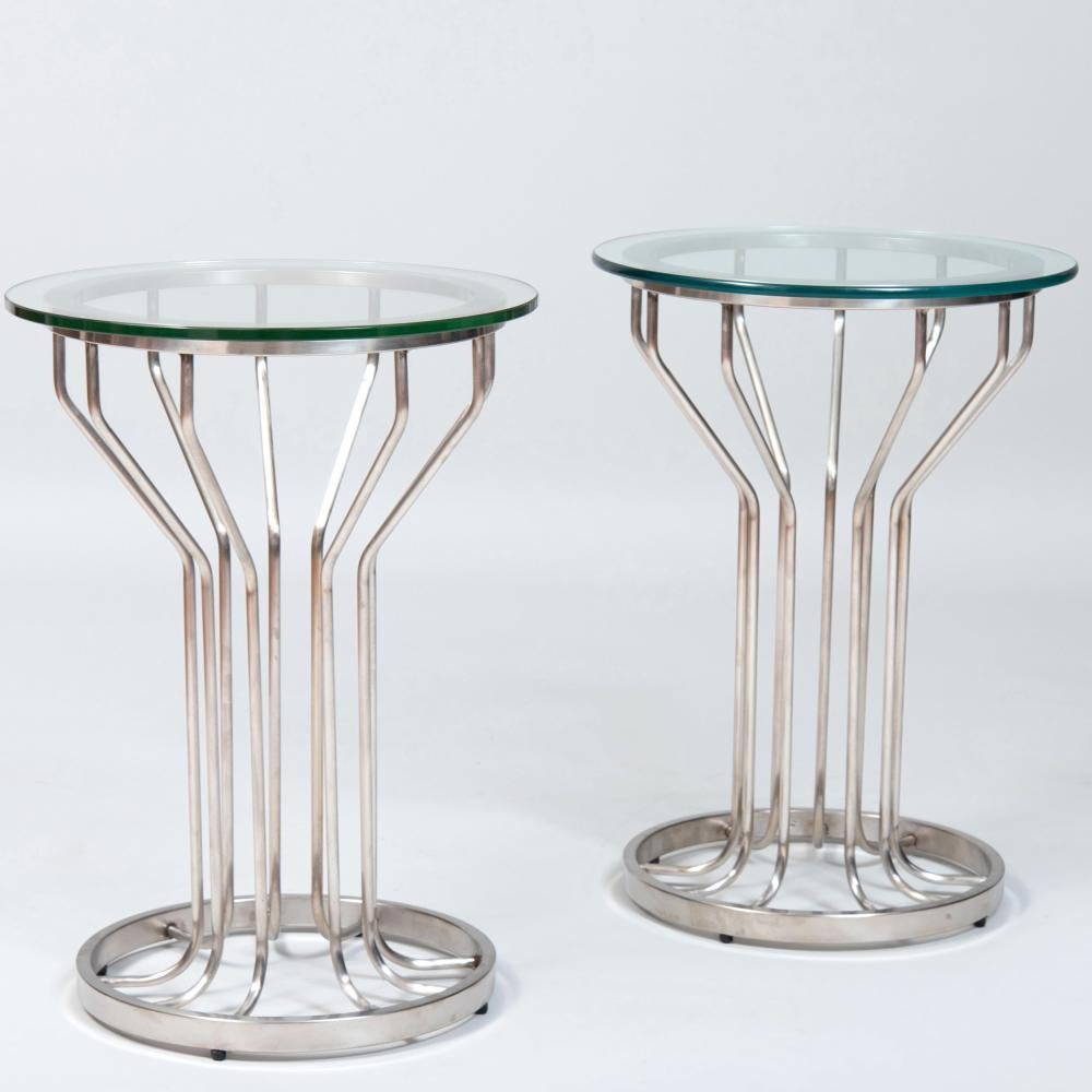 Pair of nickel and glass circular side tables. Very good condition with an excellent height of 22 inches. Sturdy bases make them perfect for sculpture of lighting as well.