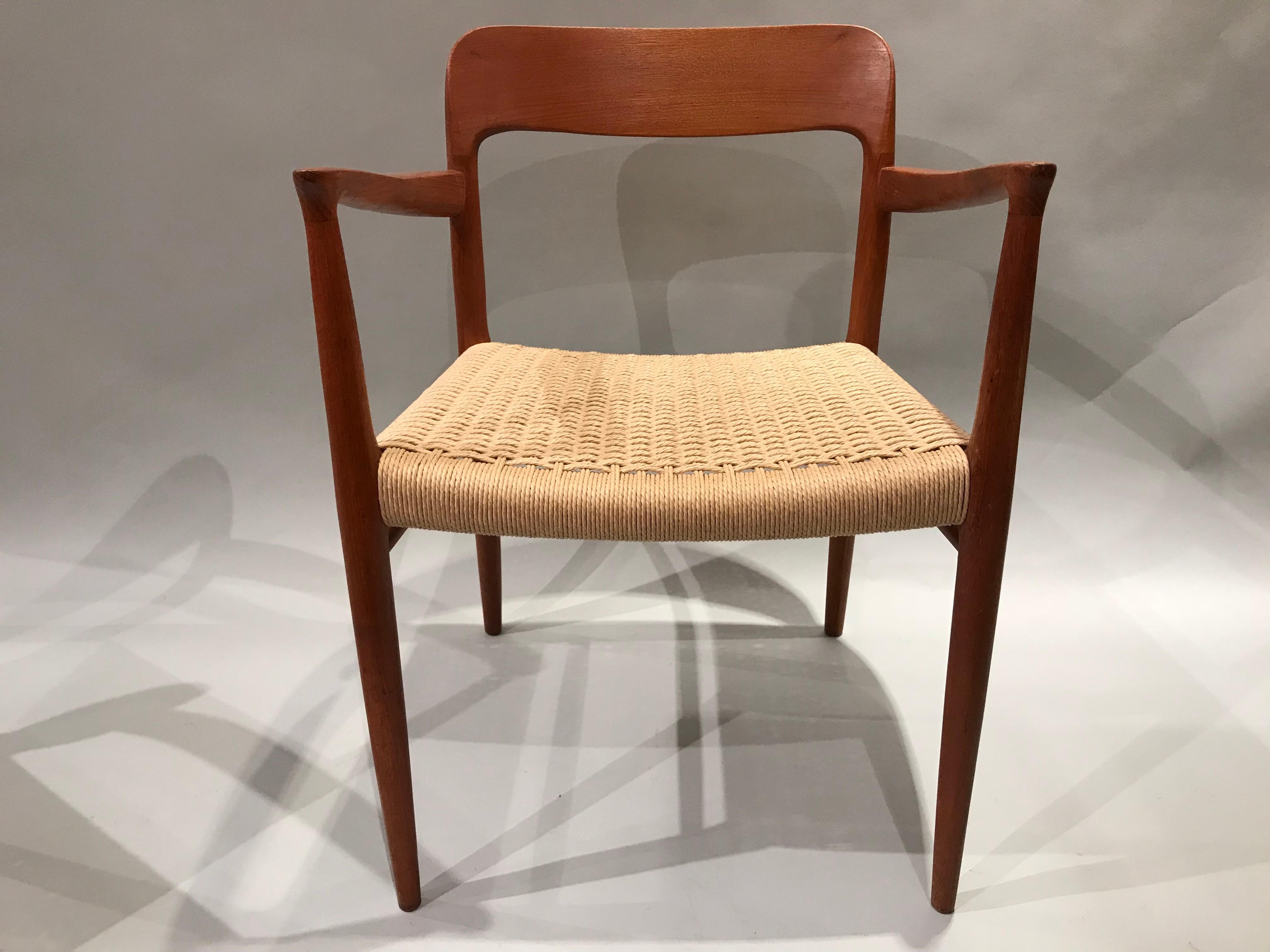 A fine pair of postwar Danish modern teak armchairs with new paper cord seats, designed by Niels Otto Møller for J.L. Møller Møbelfabrik, which was founded by famous Danish furniture designer Niels Otto Møller in 1944. Møller chairs became a coveted