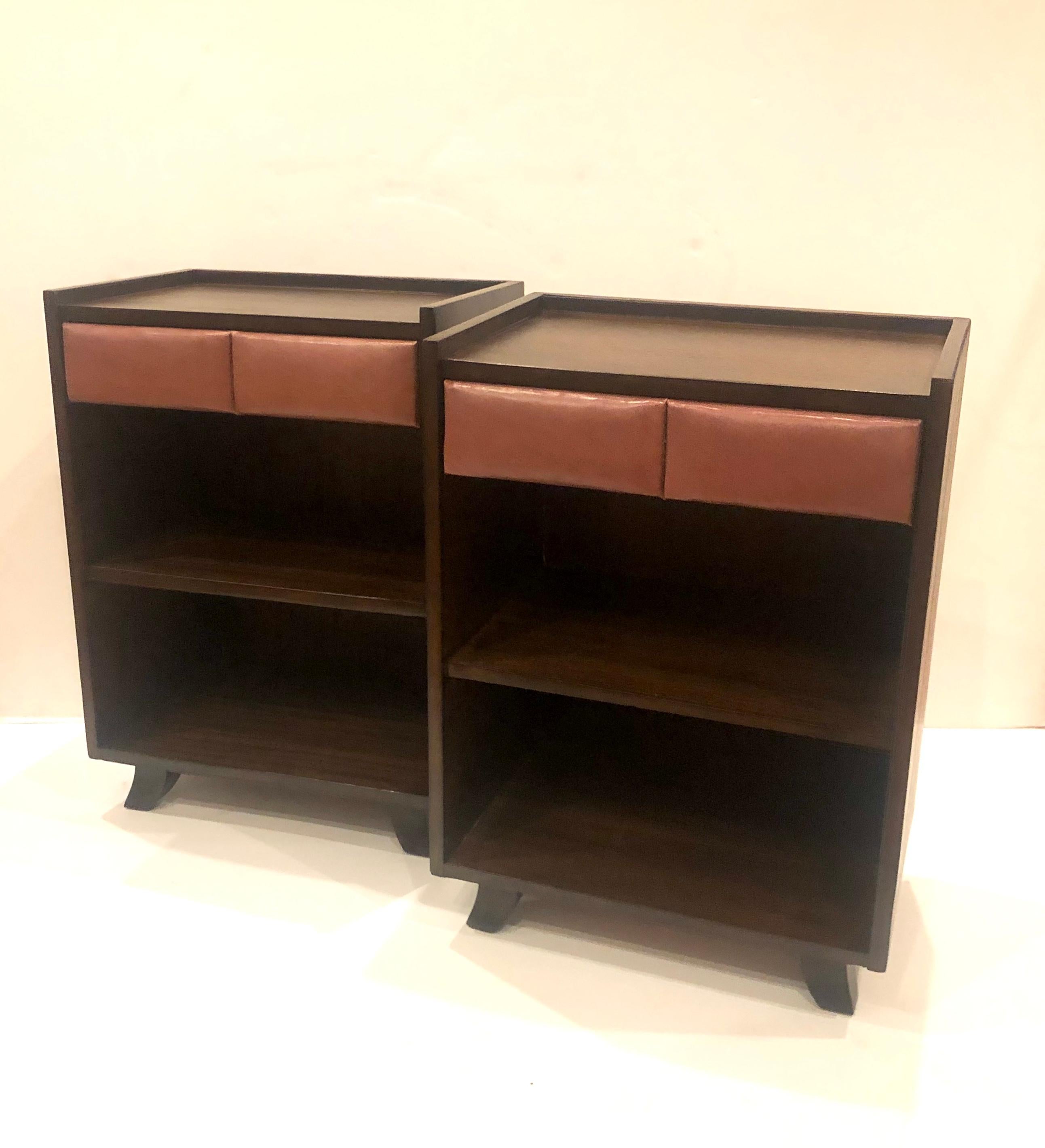 Rare pair of night stands design by Gilbert Rohde for Herman Miller, circa 1940s freshly refinished in chocolate mahogany finish retains its original Naugahyde upholstered front drawer, these pair are simple elegant and practical a perfect example