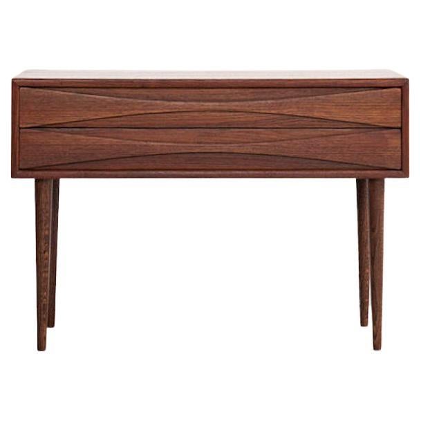 Rosewood cabinets by Niels Clausen for his own company NC Møbler produced in Odense, Denmark, circa 1960. Each wide cabinets has two slim drawers with elegant scalloped drawer-pulls and solid turned and tapered legs.