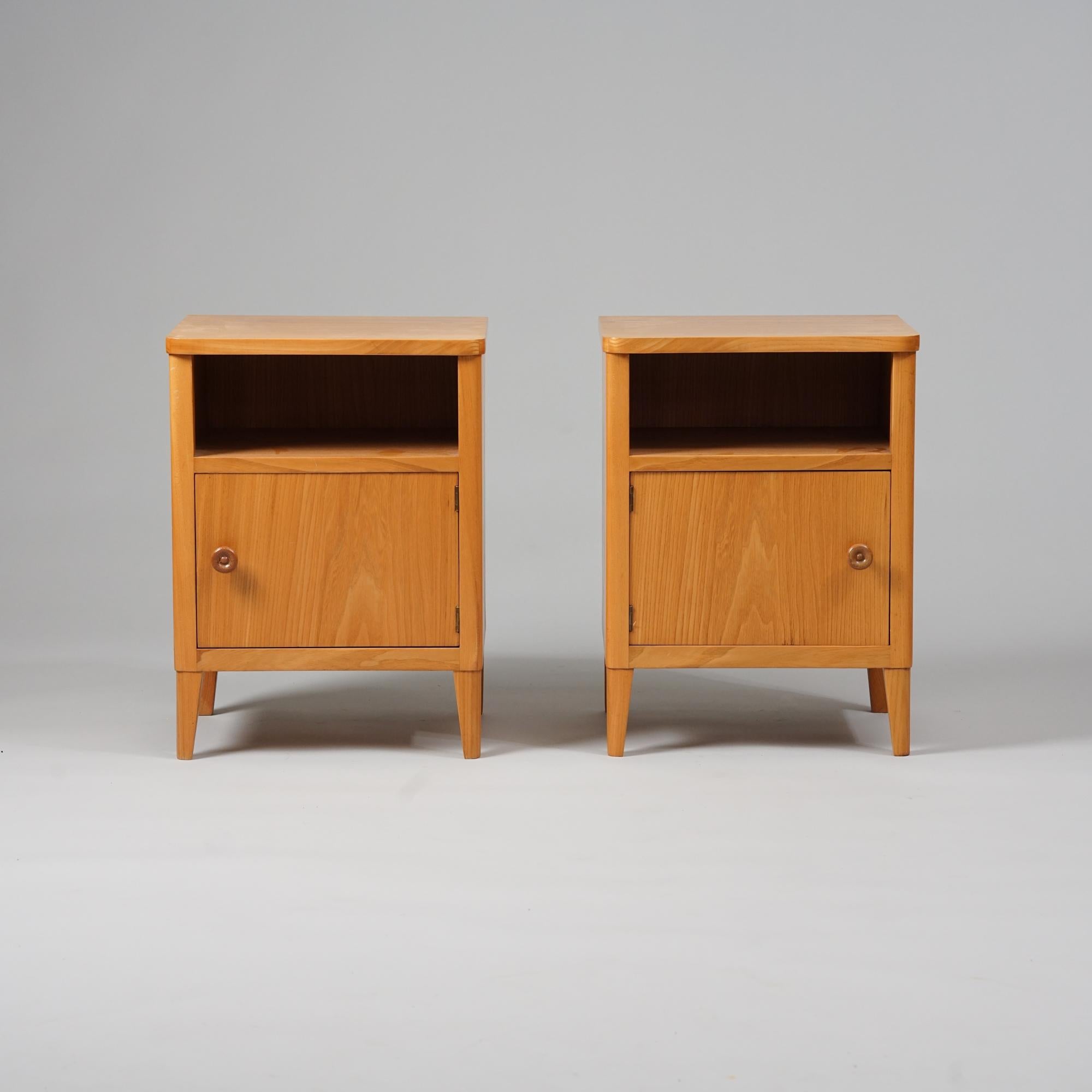 Pair of night stands, design Carl-Johan Boman, manufactured by Oy Boman Ab, 1940/1950s. Elm. Good vintage condition, minor patina consistent with age and use. Classic Boman style design. 

Carl-Johan Boman was a Finnish furniture maker and one of