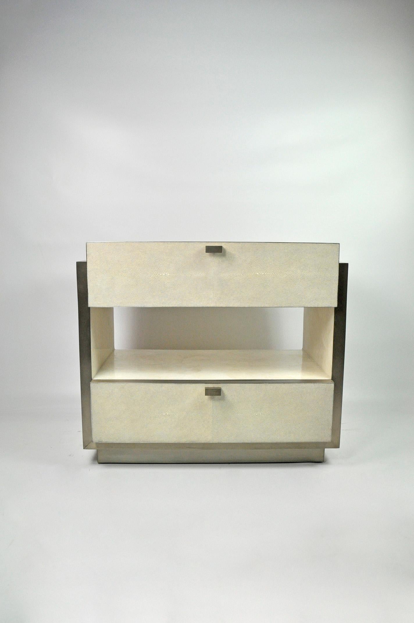 This rectangular bedside table has two drawers and it is made of white rock crystal marquetry with shagreen drawers.
The edges and the base have brushed stainless steel trims.
The handles are in stainless steel.

The dimensions of this piece are