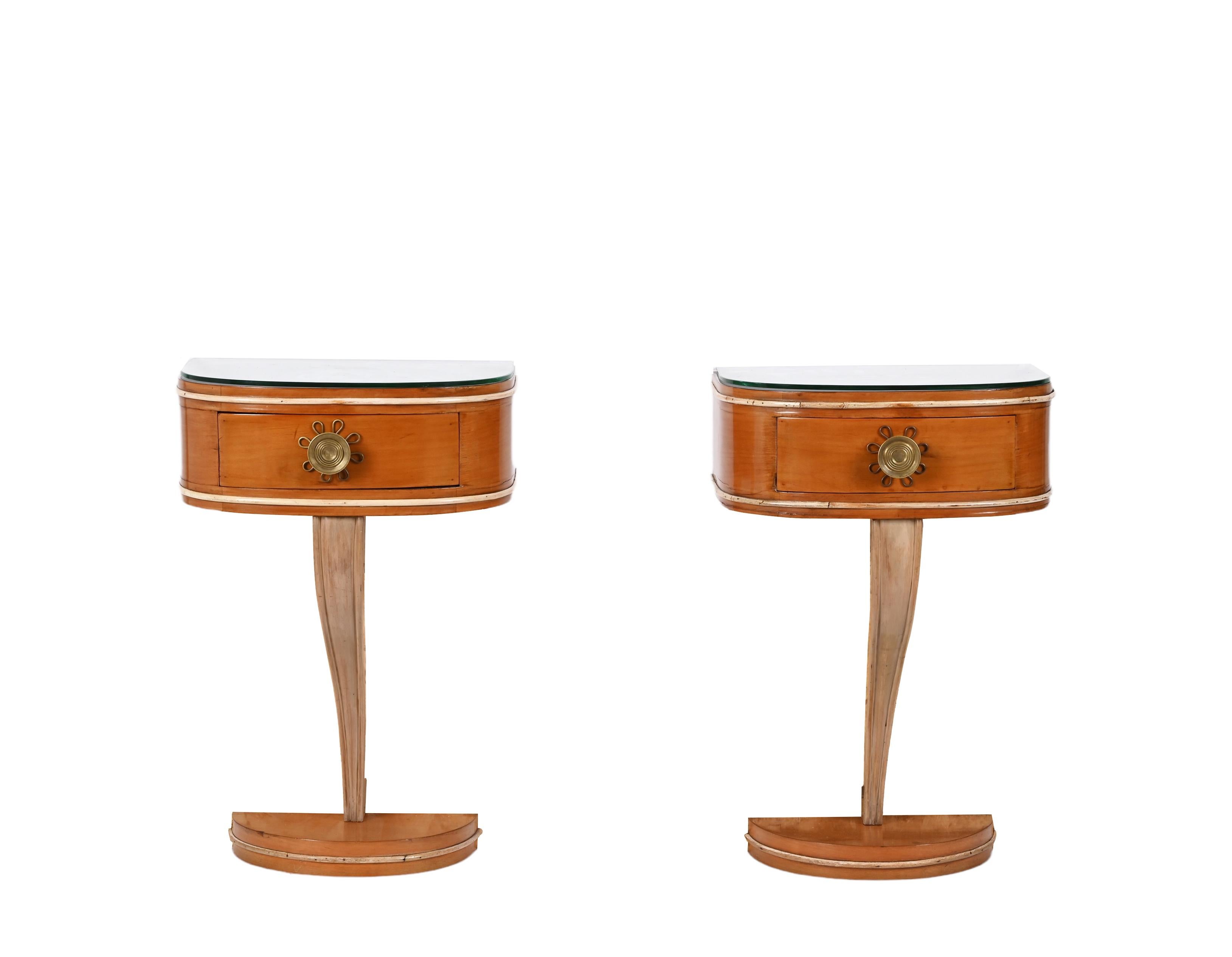 Incredible pair of Italian bedside tables by Valzania made in Italy in the 1930s. The top is made in cherry wood and connected to the bottom by a curved elegant beech wood piece. The top is covered with a glass with stunning brass handles and maple