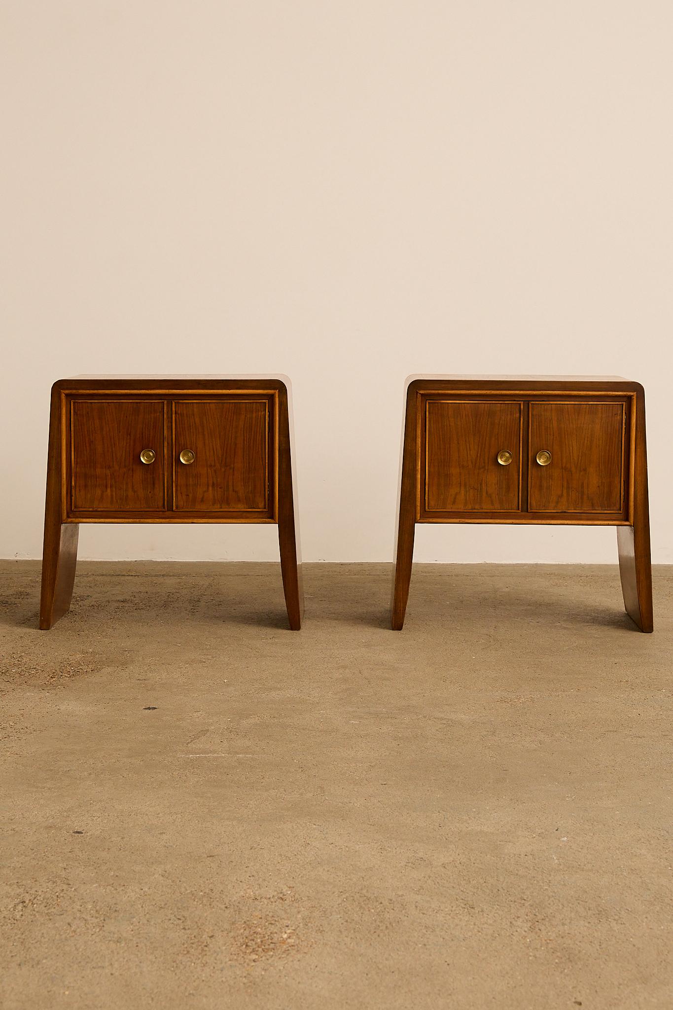 Paire de tables de nuit attribuées à Paolo Buffa, Italie, années 1950. Fabriqué de manière experte en bois aux tons chauds, le design présente des bords gracieusement incurvés et des proportions raffinées. Chaque pièce est équipée de doubles portes