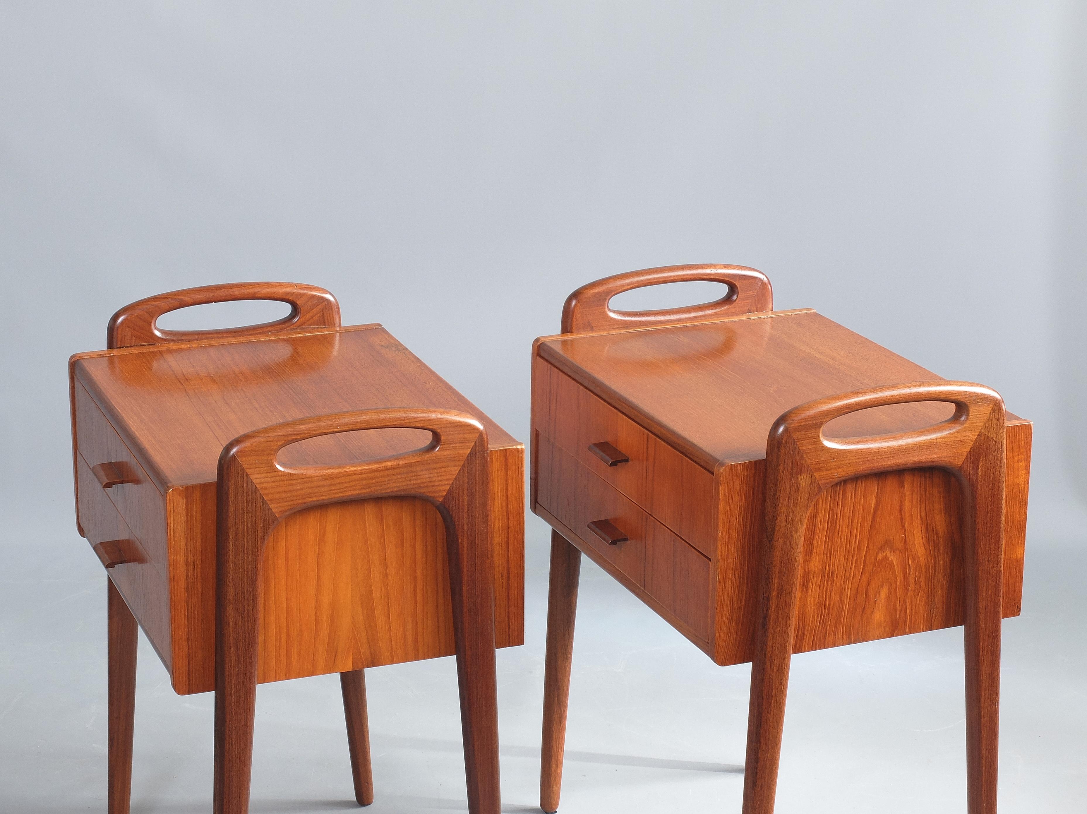 A beautiful pair of hard wood nightstands designed by Johannes Andersen, Denmark, circa 1960. Each bedside table features two drawers with delicate pulls and an integral handle formed at the top of the legs. An elegant pair of quality stands that