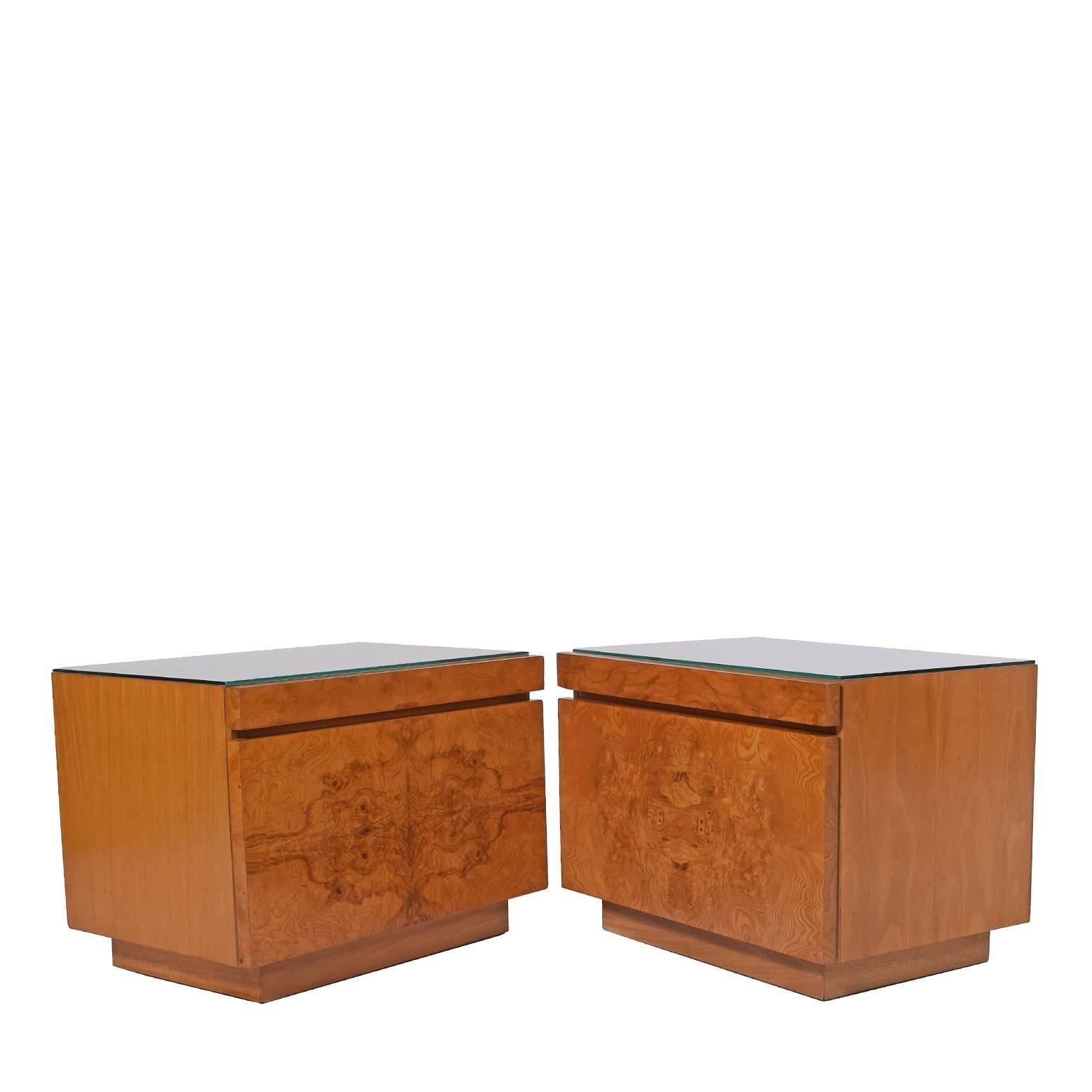 Pair of nightstands featuring burl maple front, one drawer and pull-out shelf in white laminate. Glass tops included.