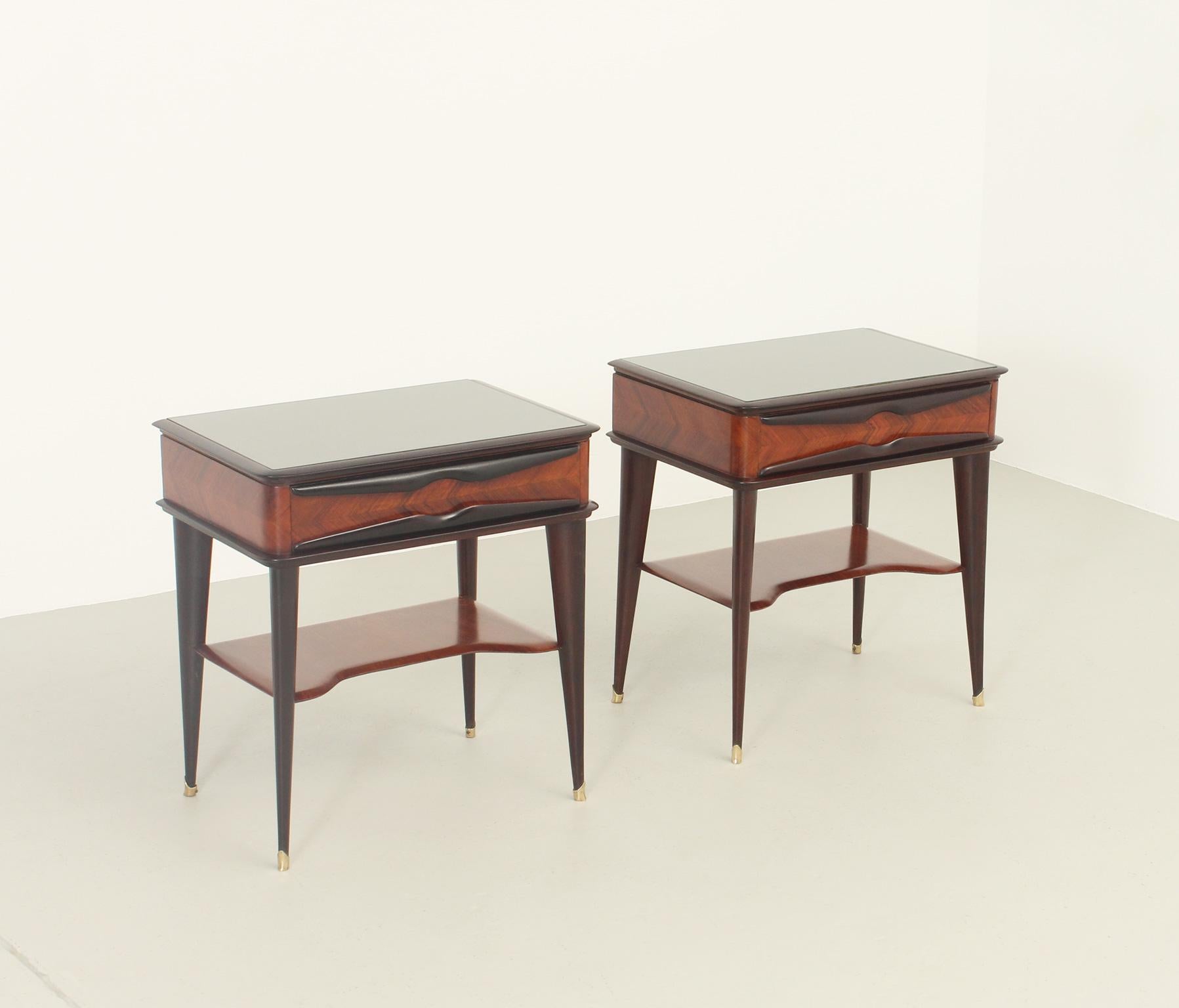 Pair of nightstands designed in 1950's by Vittorio Dassi for Dassi Mobili, Italy. Hardwood and mahogany wood with original top in colored glass and the characteristics brass feet of Dassi.