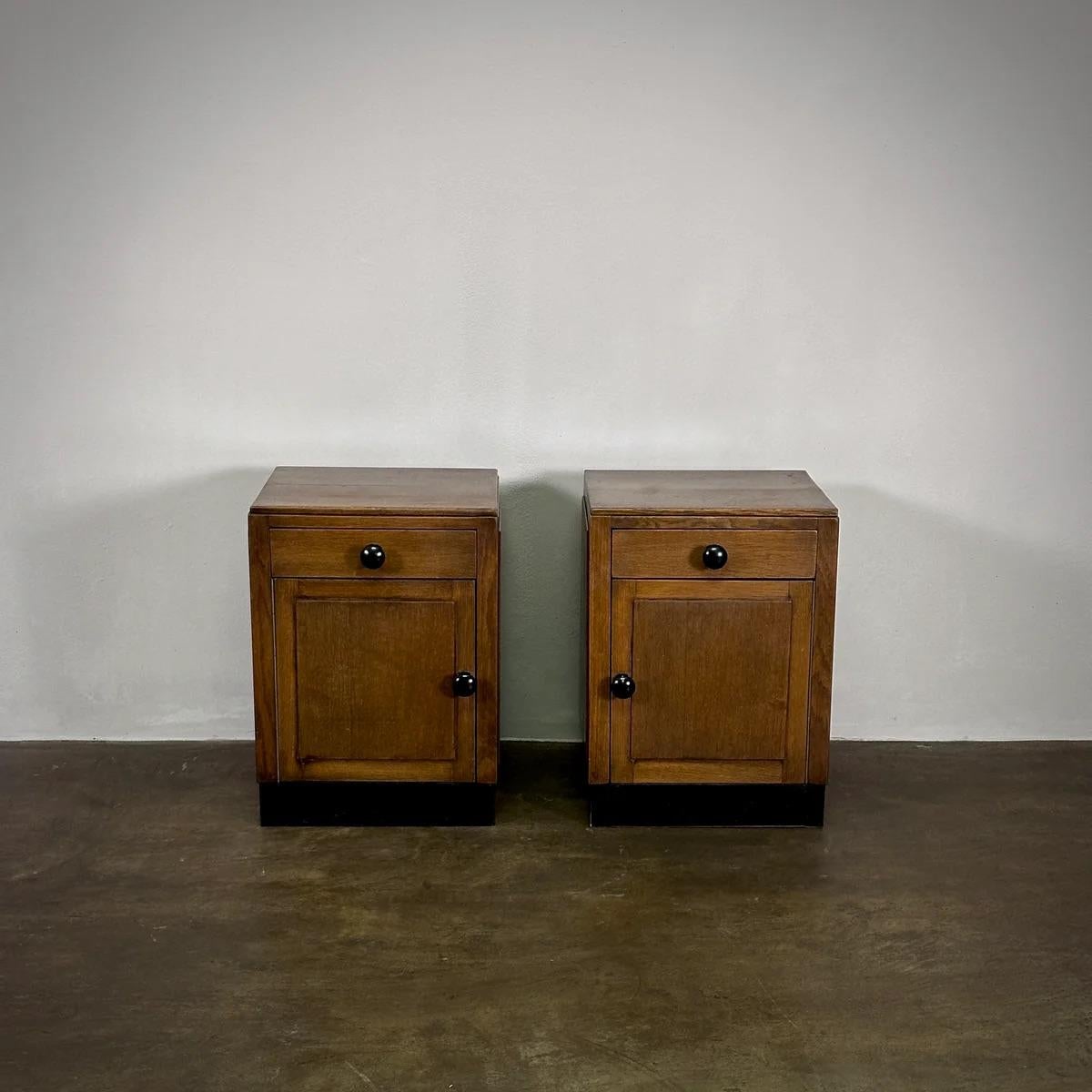 Pareja de mesillas de noche holandesas de madera maciza de principios del siglo XX, de la Escuela de Ámsterdam, lo bastante versátiles como para servir de armarios o mesas auxiliares gracias a sus respaldos acabados. Estas piezas muestran un encanto