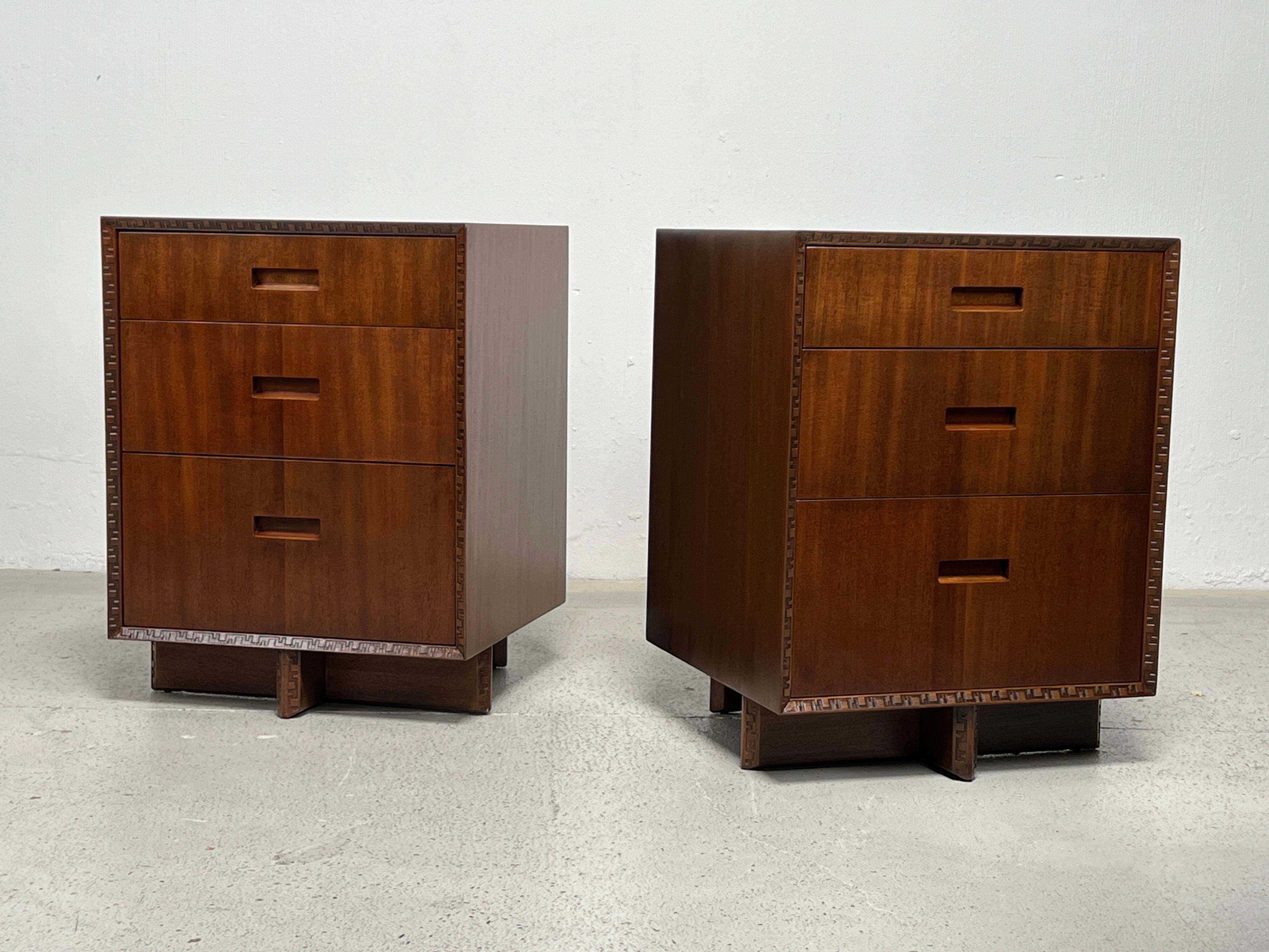 A pair of mahogany three drawer chests or nightstands designed by Frank Lloyd Wright for Henredon.