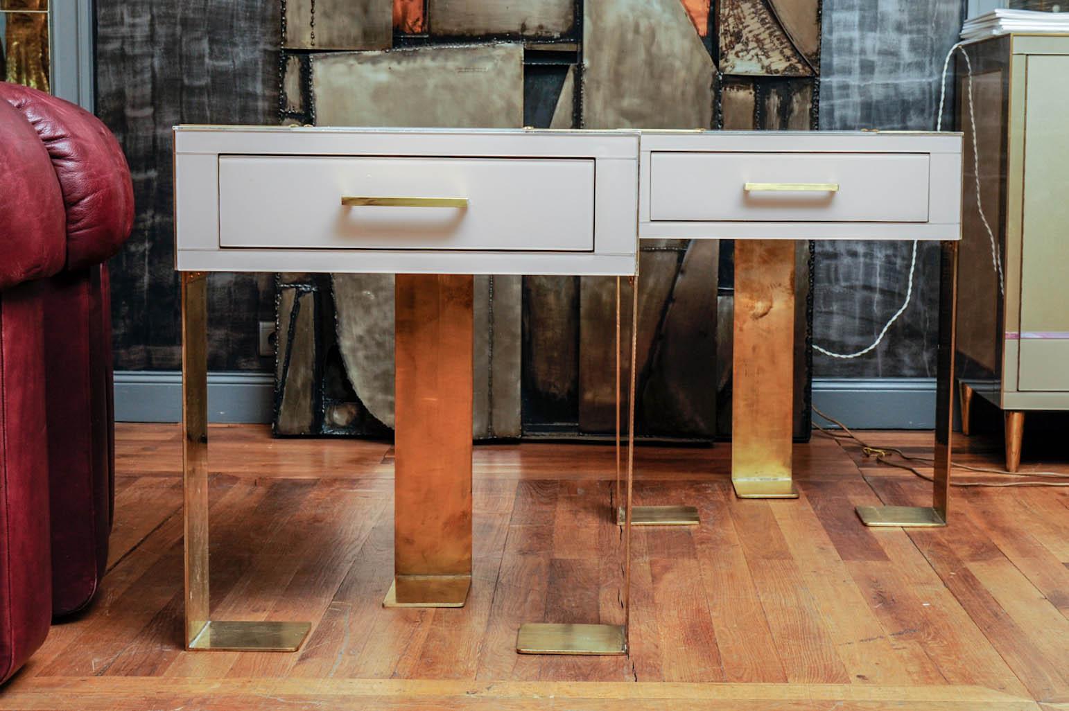 Made of brass and colored mirrors, this pair of night stands is a creation by the Studio Glustin. Standing on three brass feet, each one has a front drawer.
