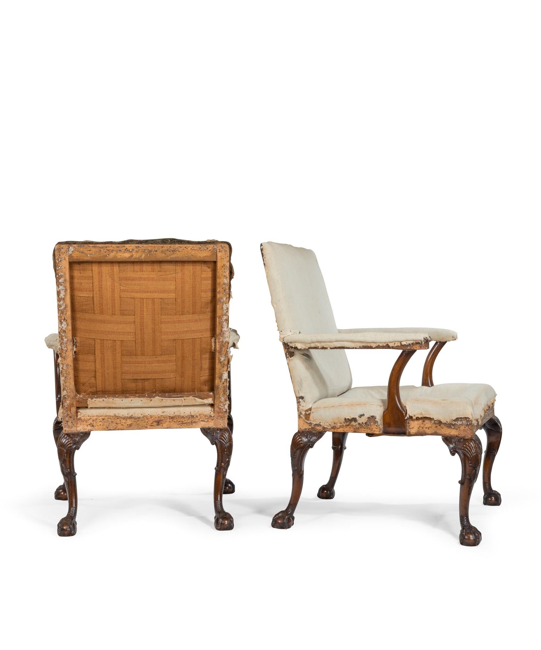 A handsome pair of early 19th century carved mahogany Gainsborough armchairs; the upholstered back and seat with upholstered back and seat and raised in crisply carved mahogany cabriole legs to front and rear. The cabriole legs are beautifully drawn