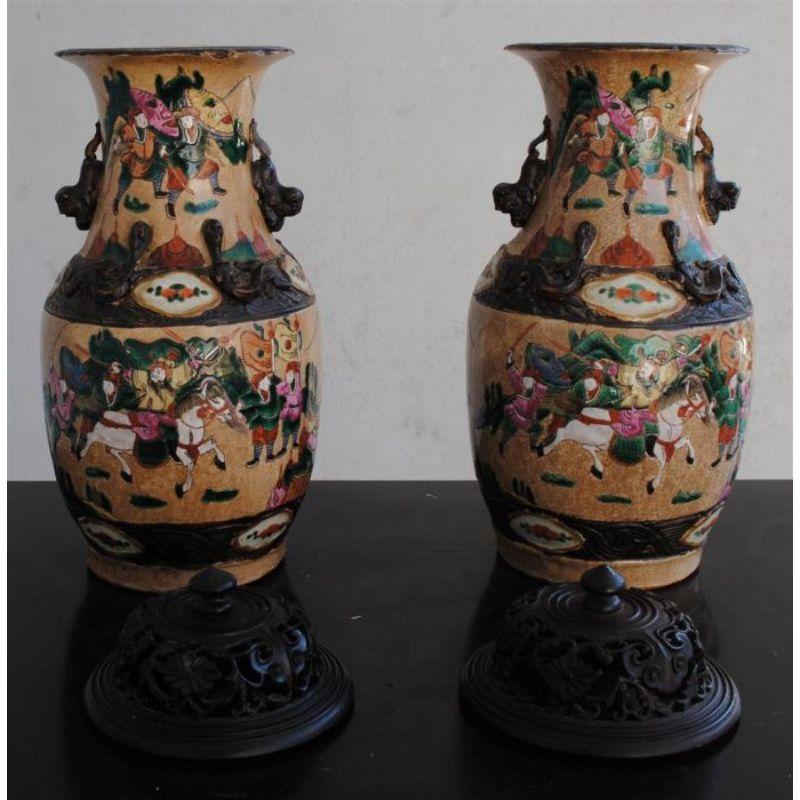 Pair of Nanjing vases decorated with a 19th century war scene with openwork wooden lids with some gaps on the lids. Dimension 34 cm high and 44 cm with lids.

Additional information:
Material: Earthenware & Ceramics.
 