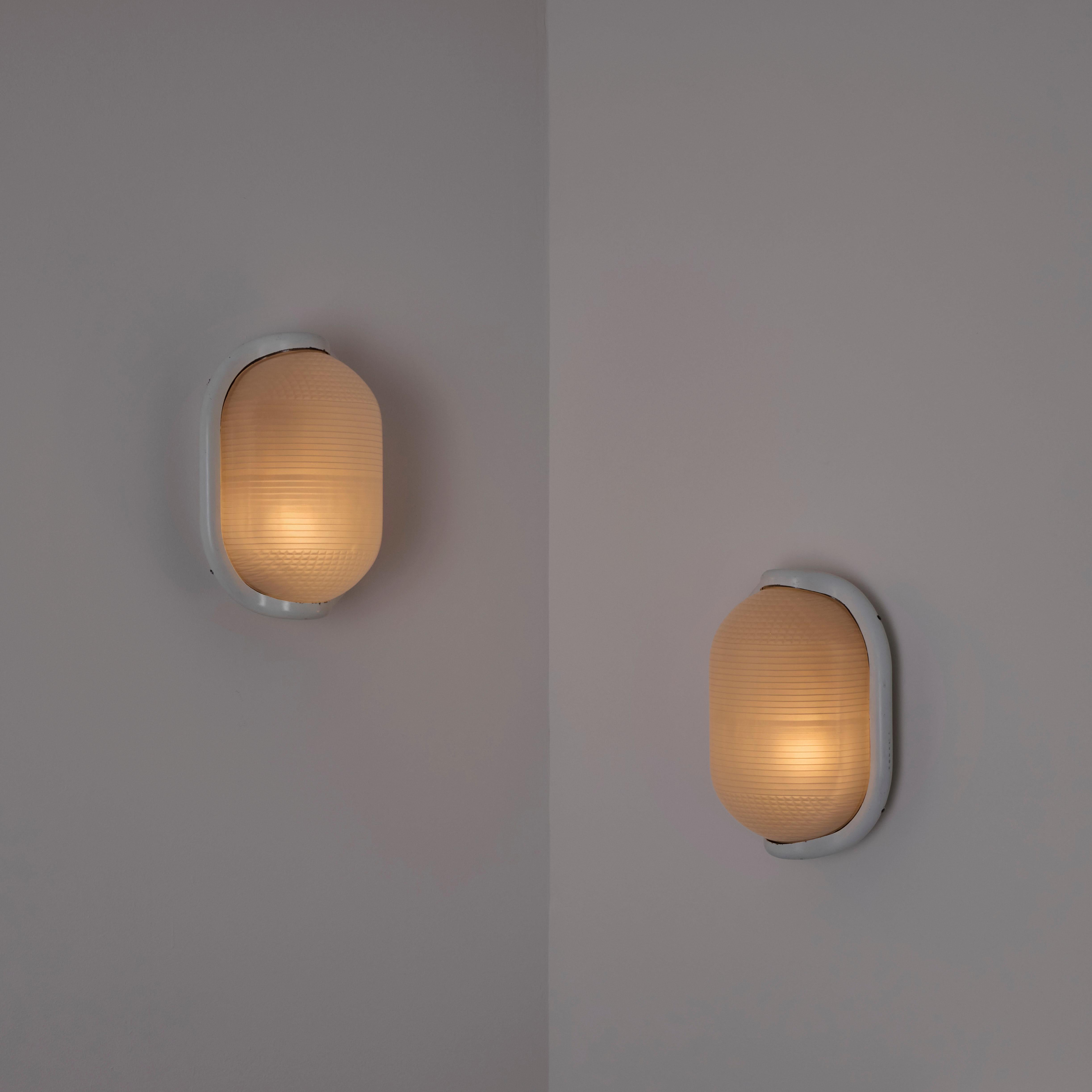 'Noce' sconces by Achille Castiglioni for FLOS. Designed and manufactured in Italy, 1972. Painted die-cast aluminum, printed glass. We recommend one E26 25-40w maximum bulb. Bulb is not included. Retains original manufacturer's label. 

Literature:
