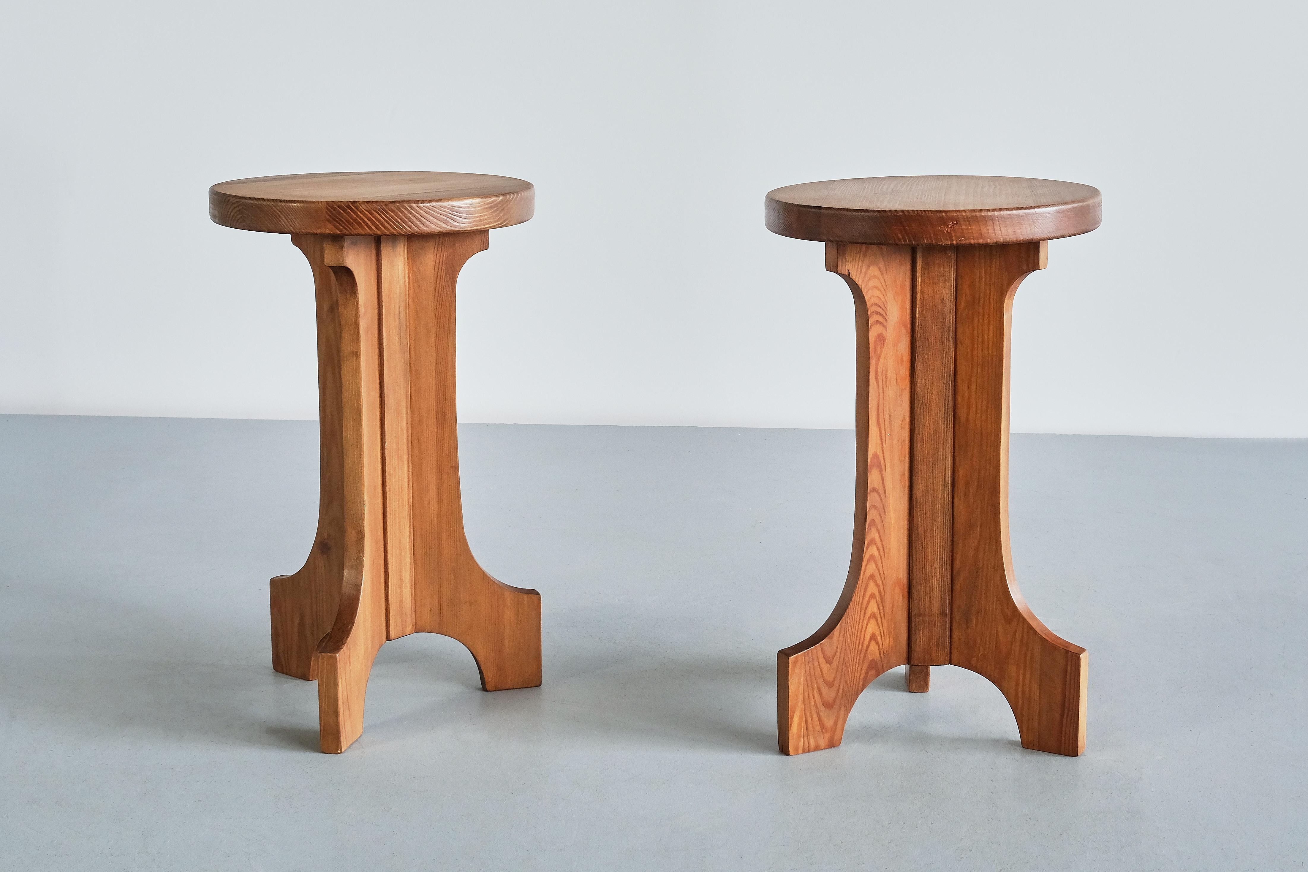 This rare pair of stools/ side tables was produced by Nordiska Kompaniet in Sweden in the 1940s. The tables are made of solid pine wood with a natural and beautiful patina acquired over time. The design is marked by the three-legged pedestal base