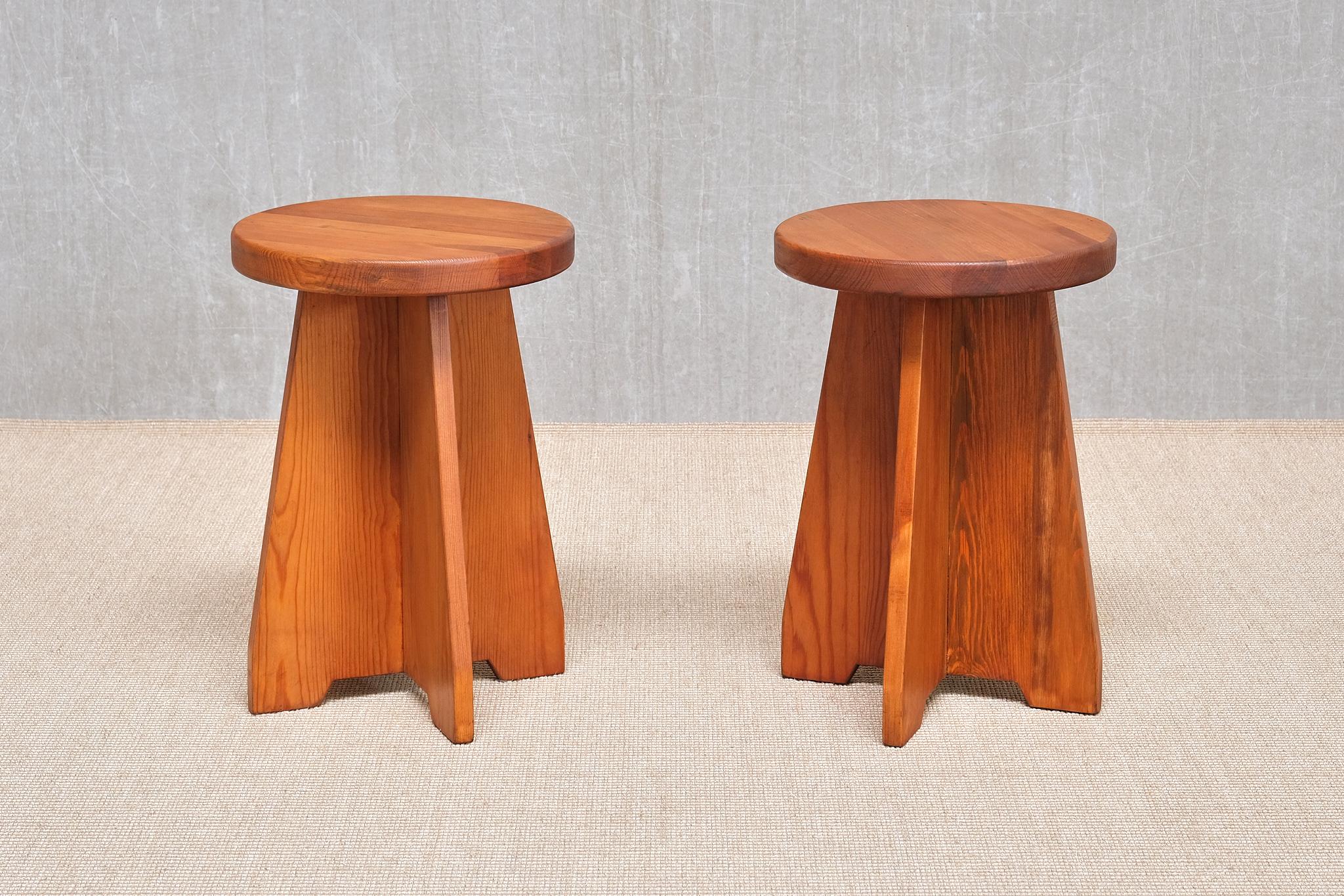 This rare pair of stools/side tables was produced by Nordiska Kompaniet in Sweden in the 1940s. Crafted from solid pine, the pieces have developed a beautiful natural patina over time. The design features a distinctive four-legged cross base and a