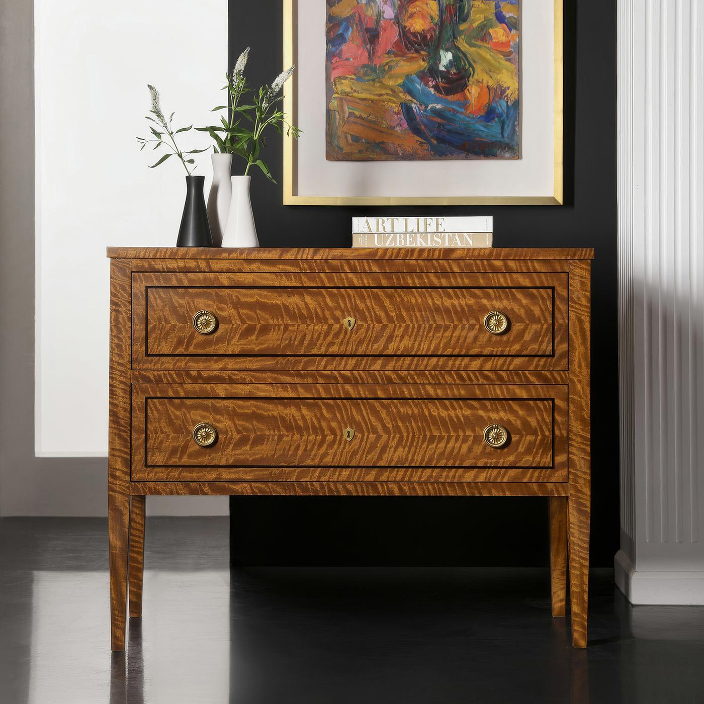 Realizzata con un'impiallacciatura esotica di movingui con raffinati intarsi neri, questa lussuosa cassapanca è un esempio di raffinatezza senza tempo. I cassetti in Oak, dotati di moderni meccanismi di chiusura morbida, garantiscono una