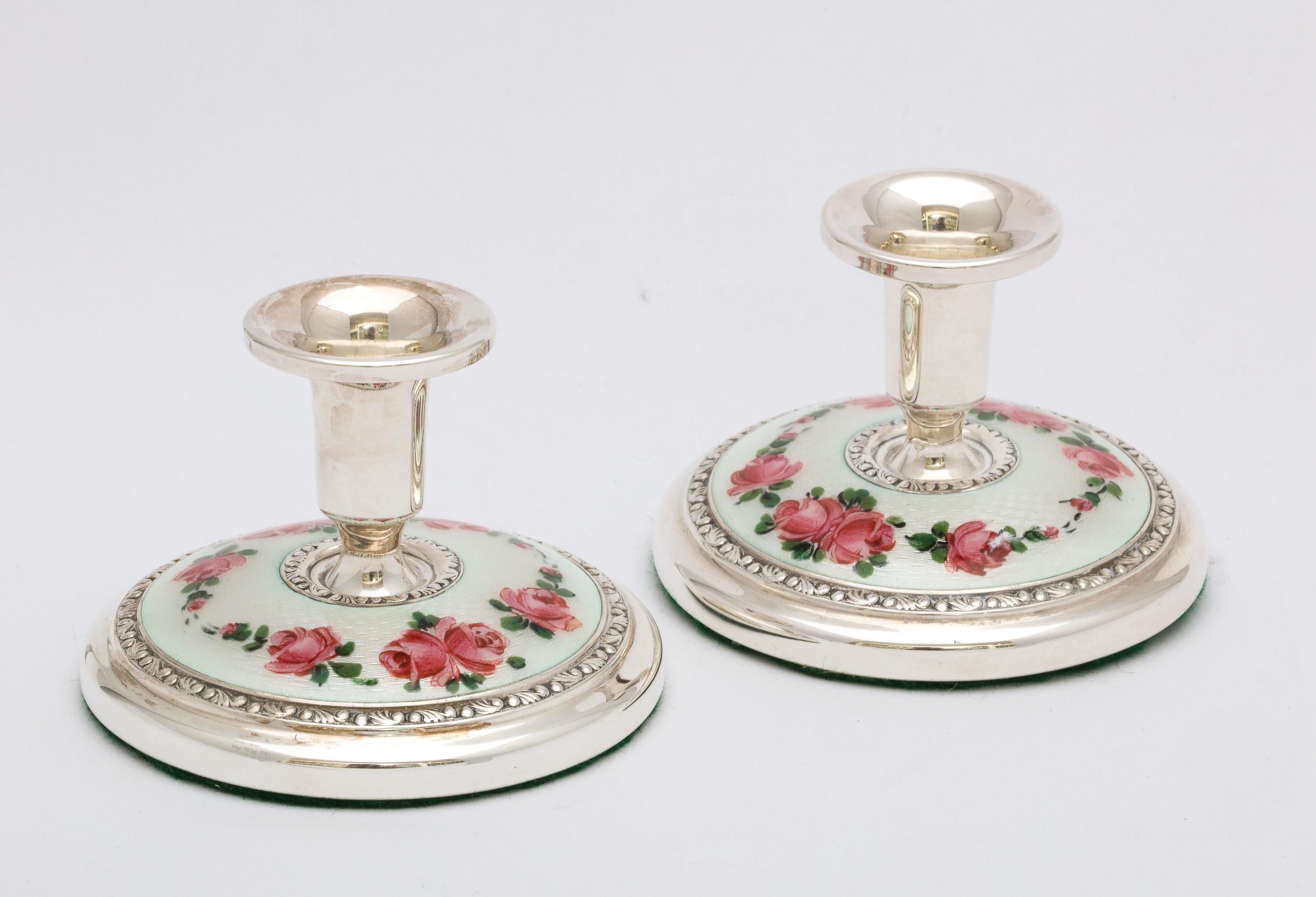 Pair of Art Deco sterling silver and white guilloche enamel (decorated with pink enameled roses and green leaves) candlesticks, Oslo, Norway, Norsk Solwarreindustri - makers, Ca. 1930's. Each candlestick measures 2 1/4 inches high x over 2 3/4