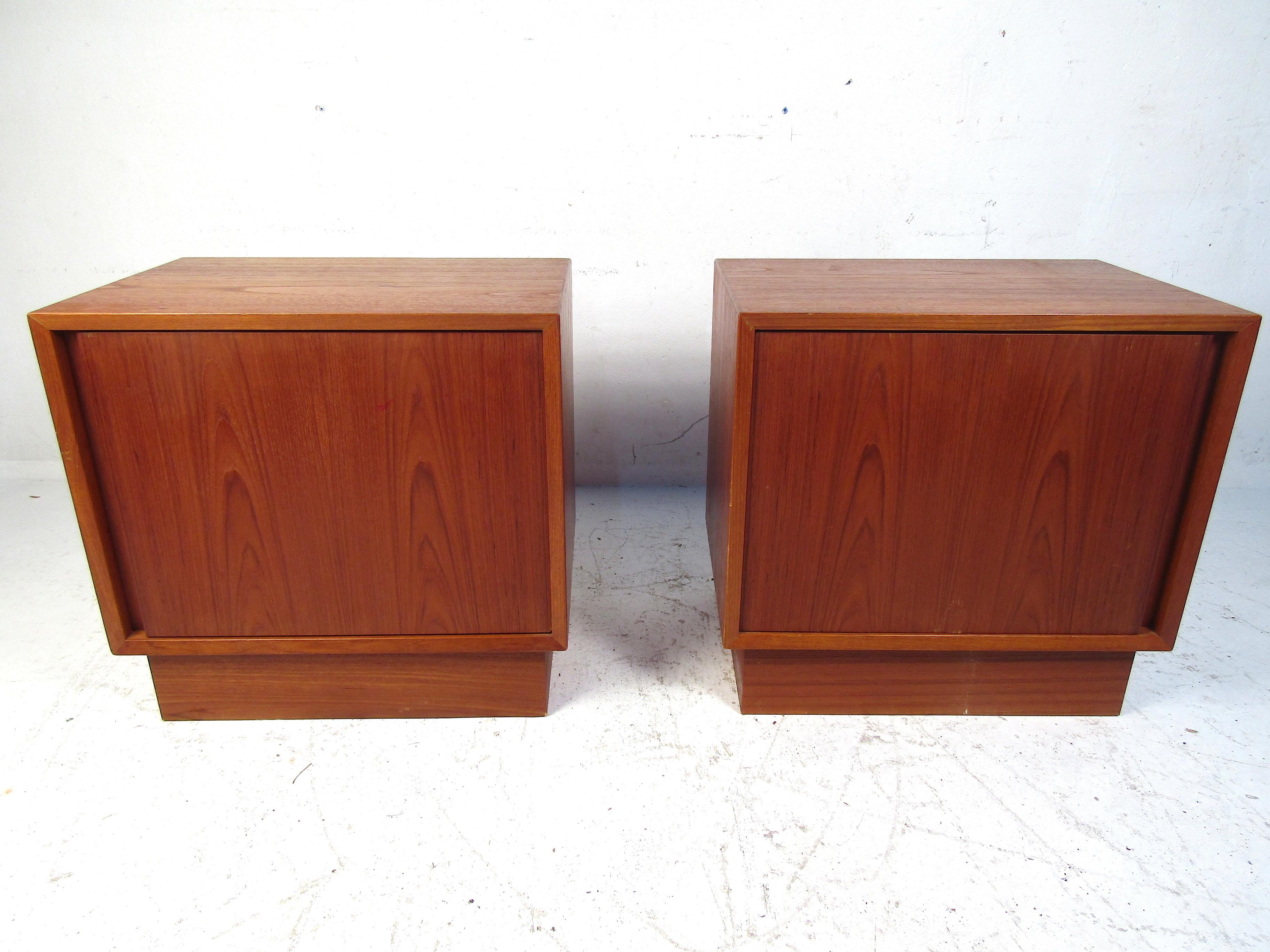 Pair of teak Norwegian nightstands. Simplistic and elegant in design featuring clean lines with a front opening cabinet on either piece. Both stands have one interior shelf with a 