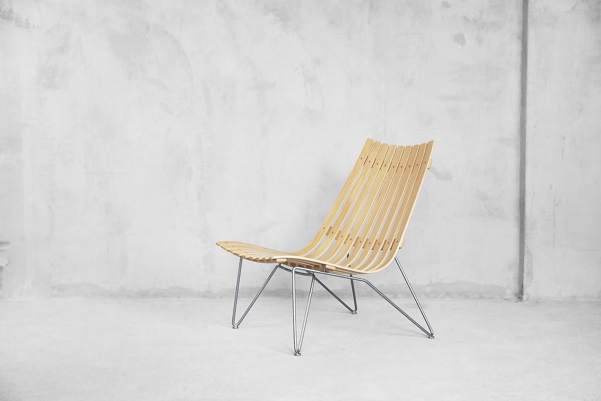 An elegant and modern Scandia lounge chairs. This model was designed by Hans Brattrud in 1957. This pair of chairs was manufactured by Fjordfiesta in Norway at the first years of 21th century. Steam-bent american oak slats rest on a frame of