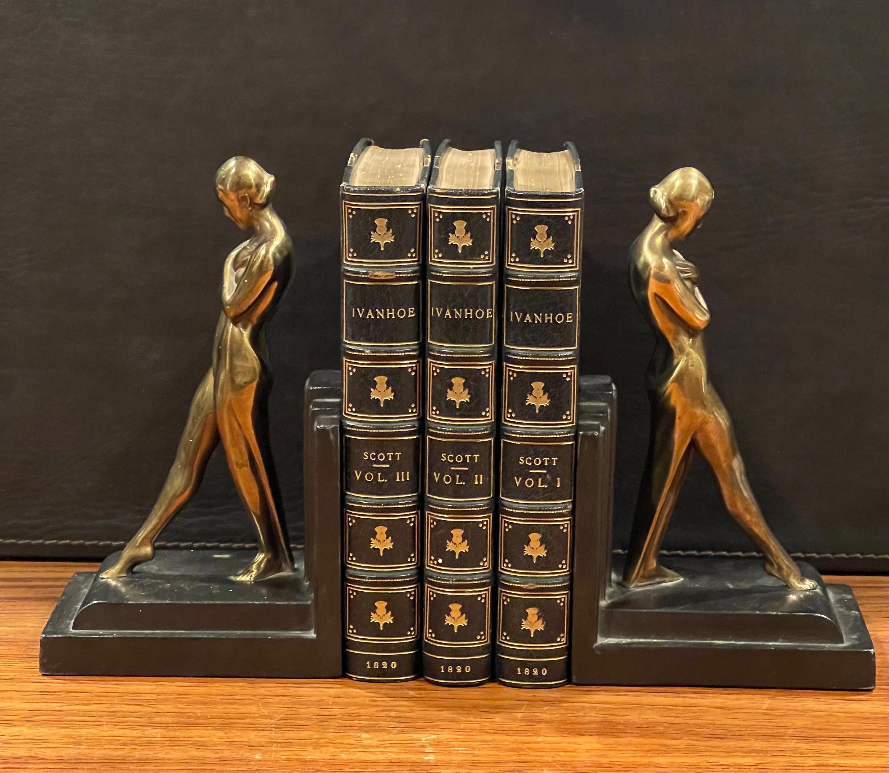 Gorgeous pair of brass nude women on metal base Art Deco bookends, circa 1930s. They are in original condition with a fine patina, some light oxidation and some surface scratches; the pair measures 9.5