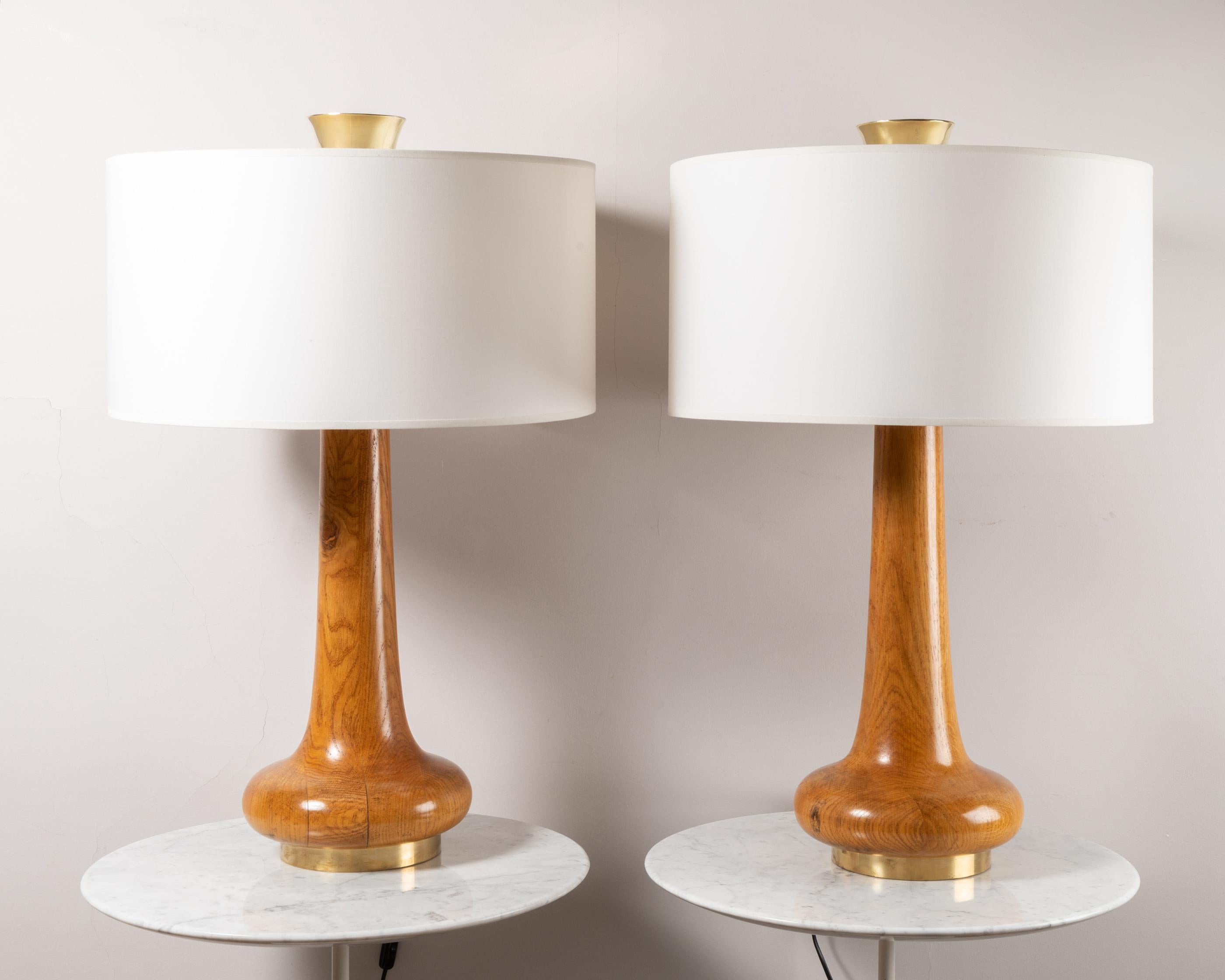 A large pair of tables lamps. 
Varnished oak with brass details.
New shades
France 1970's

Measures: Total Height : 78 cm / 30.7 in.
Shade diameter : 50 cm / 19.6 in.
  