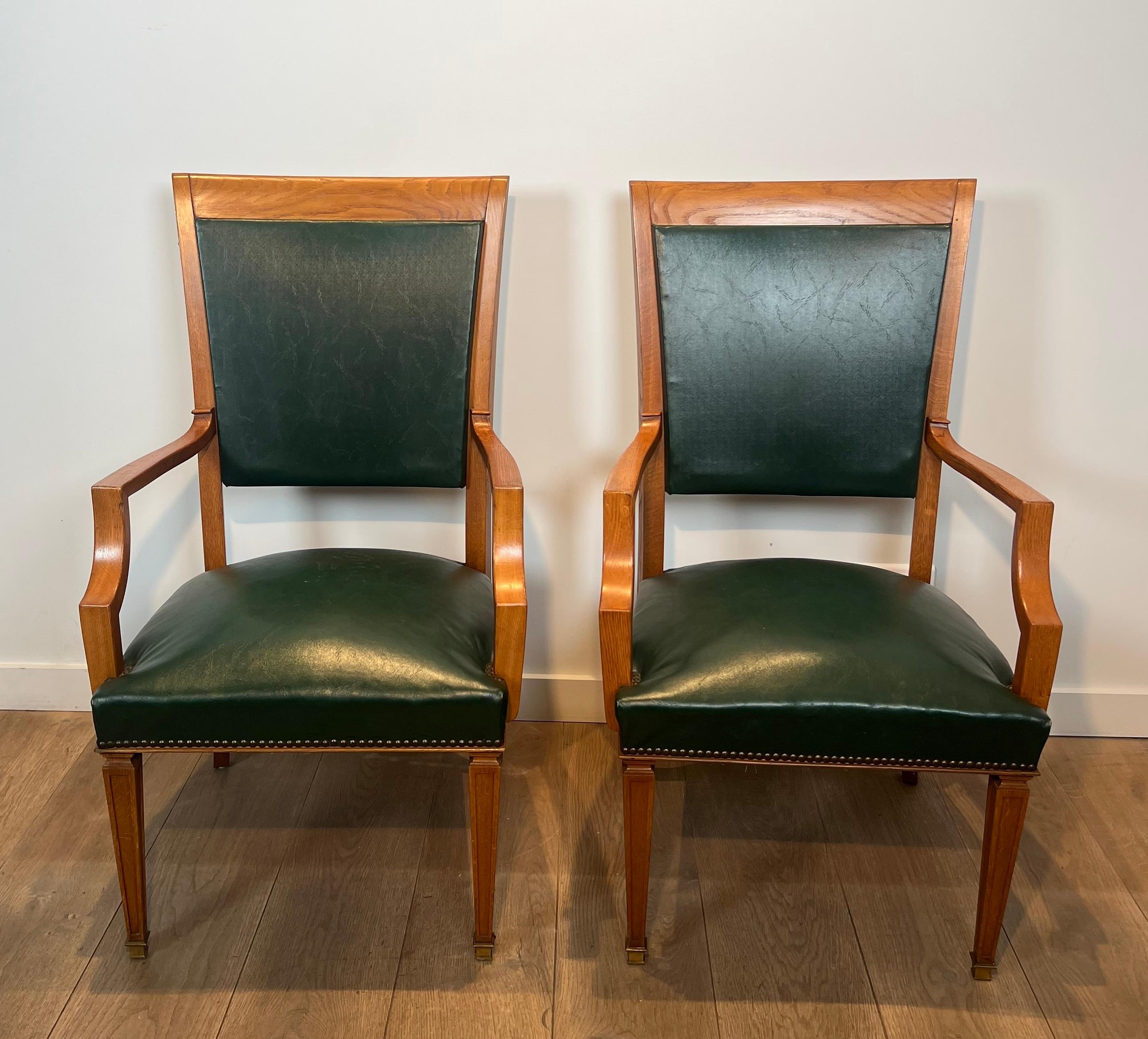 This very nice and elegant pair of neoclassical style armchairs is made of oak and leather. This is a Belgian work by De Coene Frères. Circa 1940
