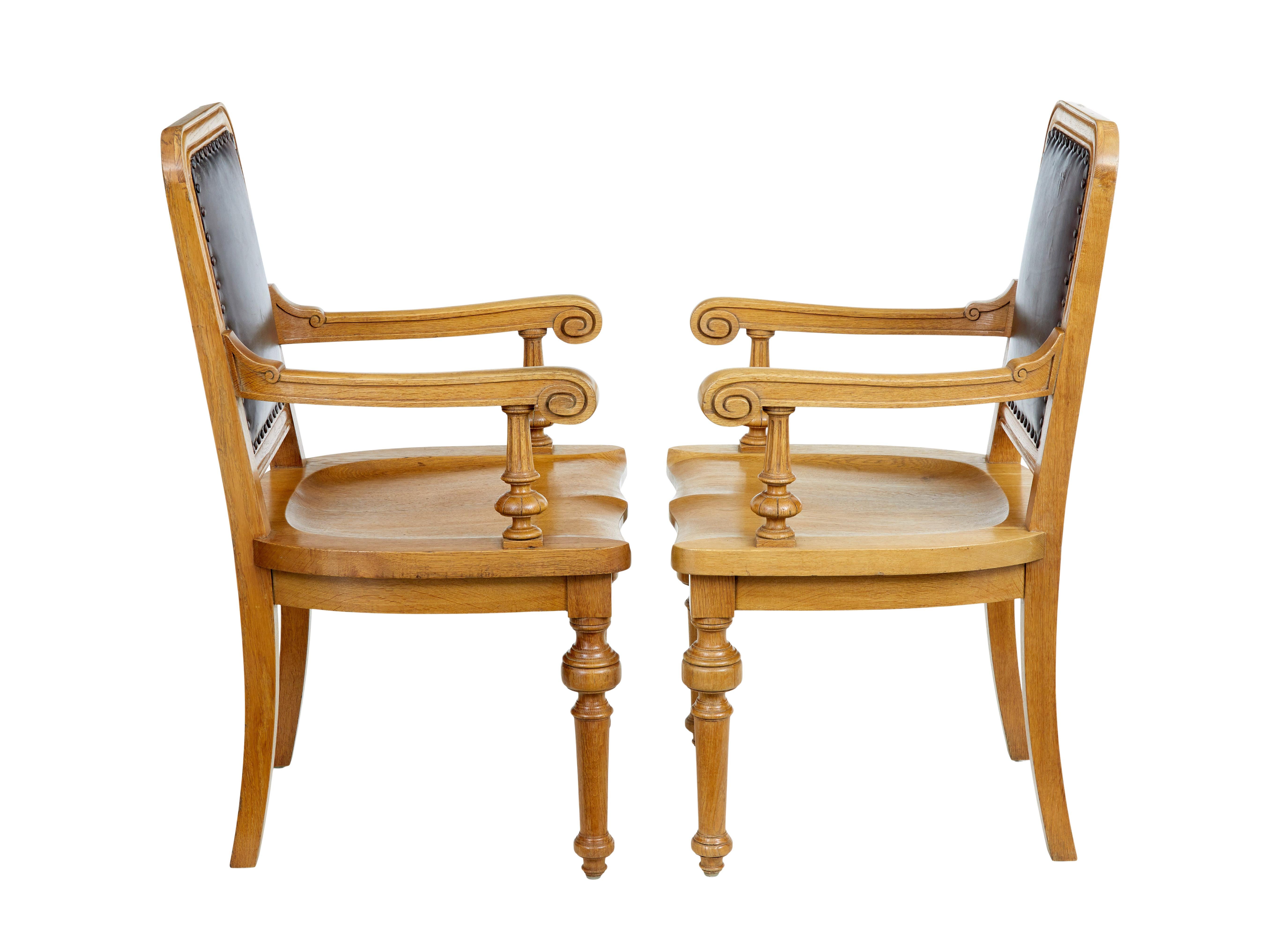 Pair of oak and leather arts and crafts library chairs 1
