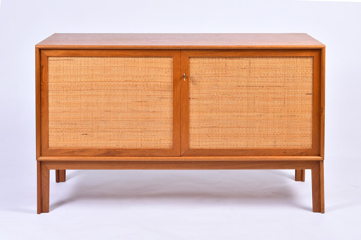 Pair of oak and rattan sideboards designed by Alf Svensson for Bjästa.
The oak cabinet opening with two rattan clad doors with a brass key, to reveal adjustable shelves and drawers, on moulded legs.
Sweden, 1950s.