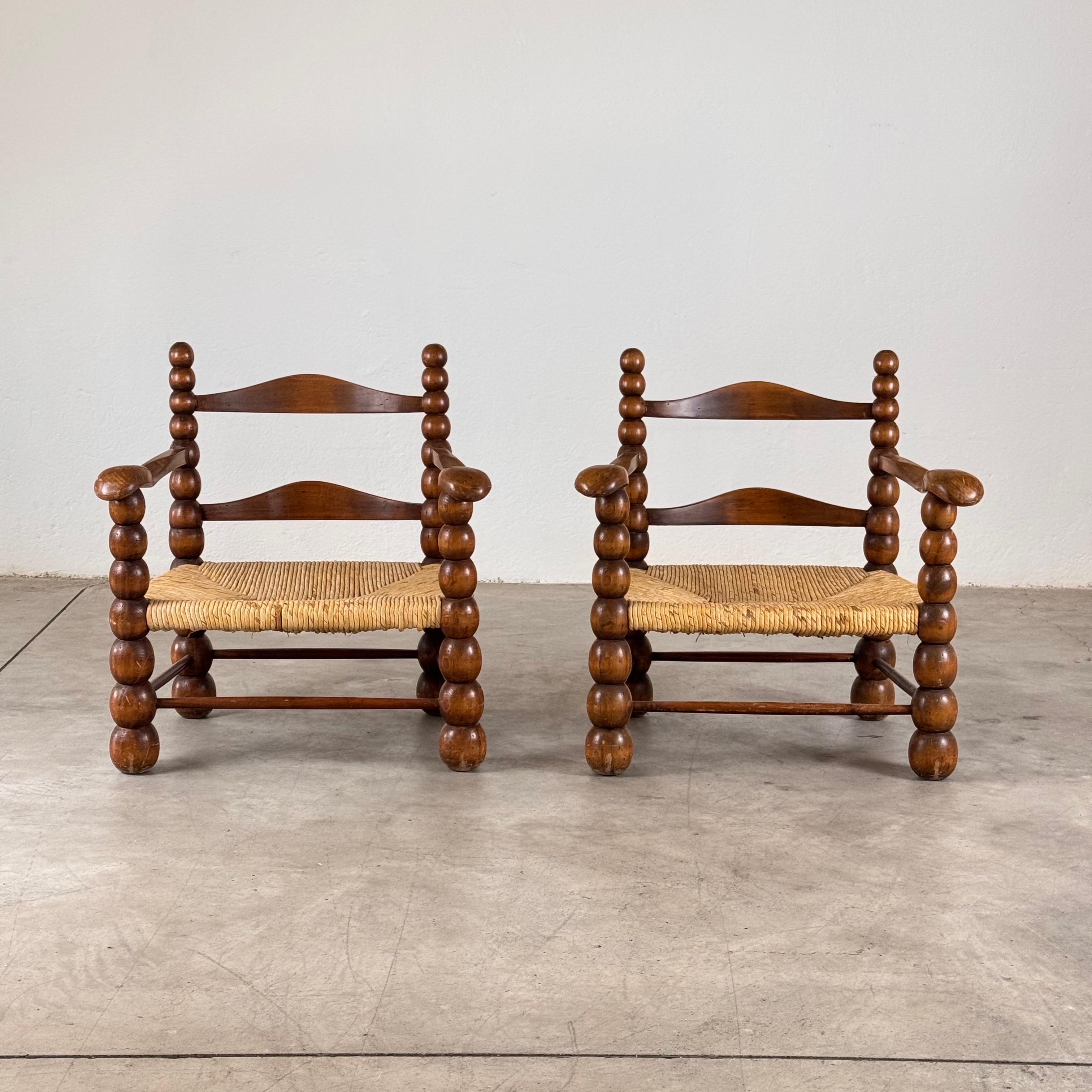 
This sophisticated pair of armchairs by Charles Dudouyt, dating to the 1930s, exemplifies the artisan’s unparalleled mastery of woodworking and design. Fashioned in solid oak with meticulously handwoven 