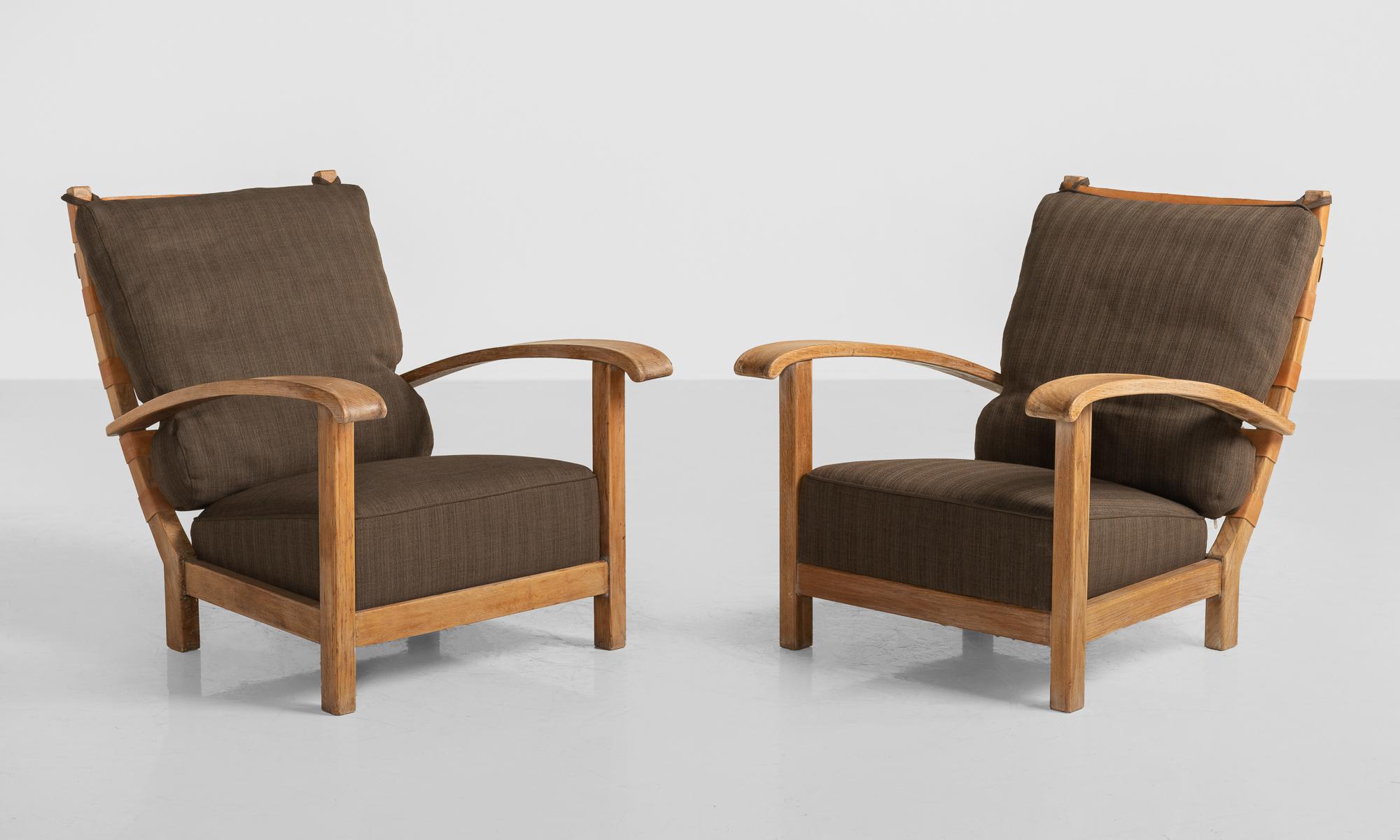 Pair of Art Deco Armchairs, Italy, circa 1950.

Solid oak frame with leather back straps and upholstered cushions.


    