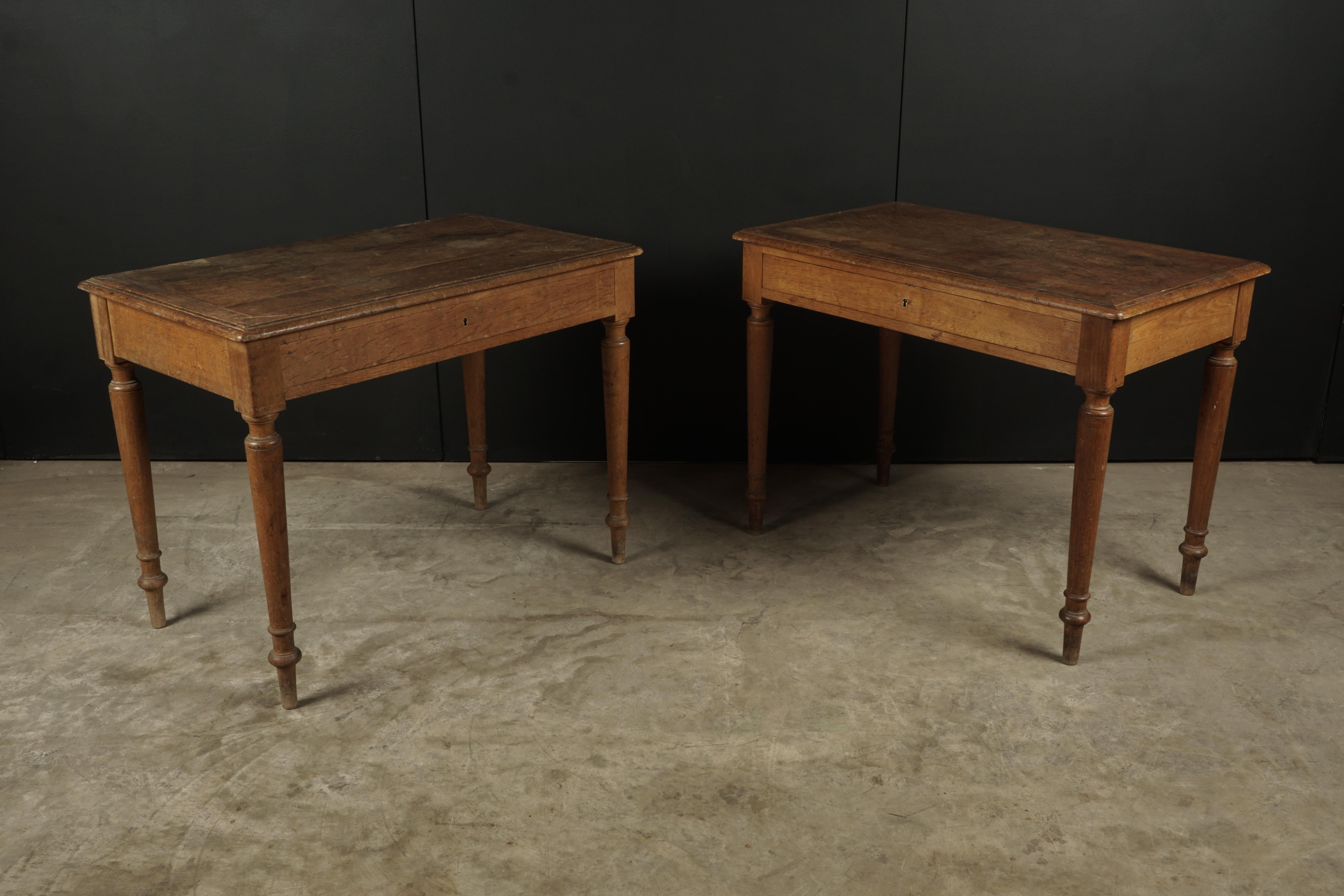 Pair of oak bistro tables from France, circa 1950. Solid oak construction with nice patina and wear.