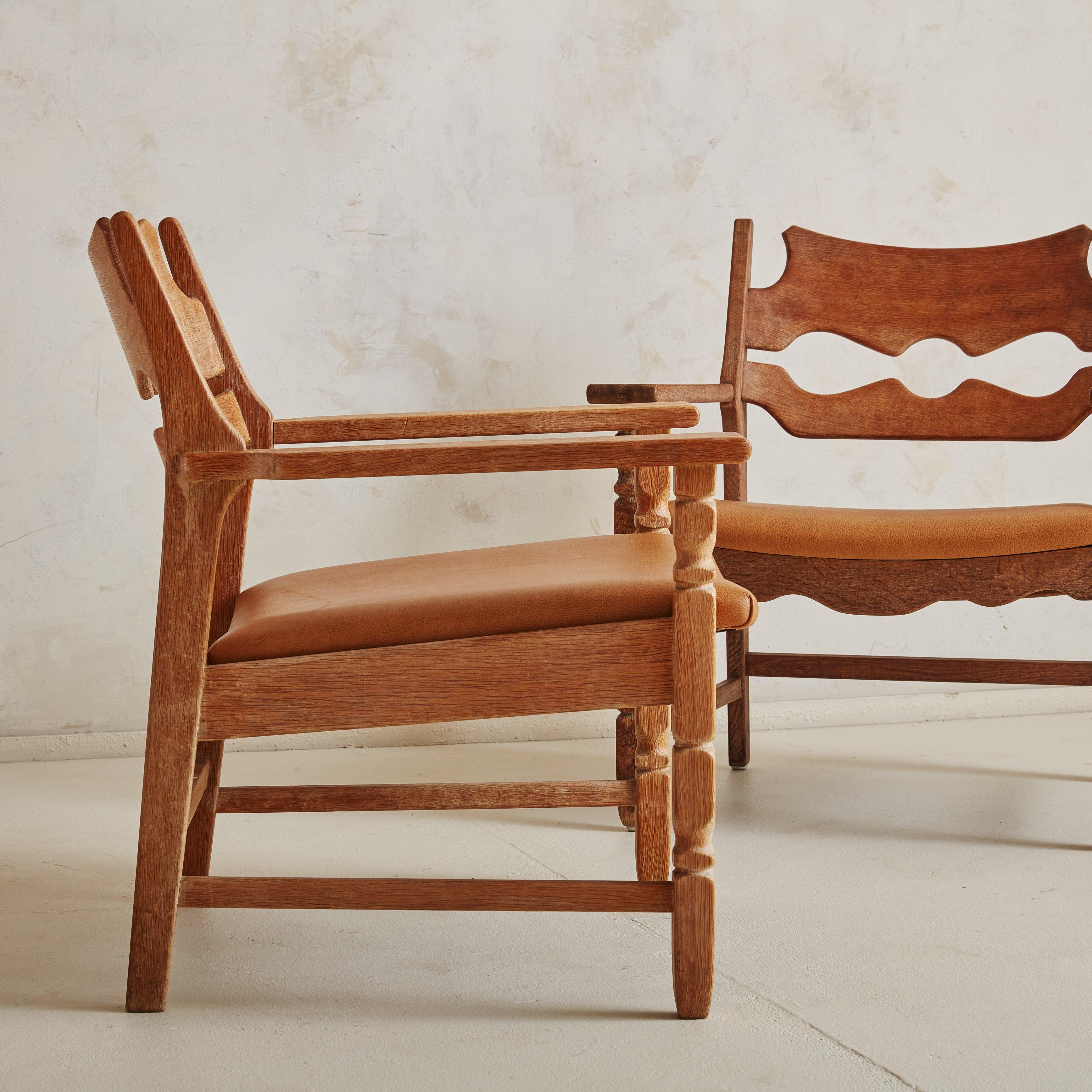 A pair of ‘Razorblade’ armchairs attributed to Danish furniture designer Henning Kjærnulf for EG Møbler in the 1970s. The Scandinavian Modern frames are crafted of solid oak and feature freshly upholstered camel leather seats. They sit comfortable