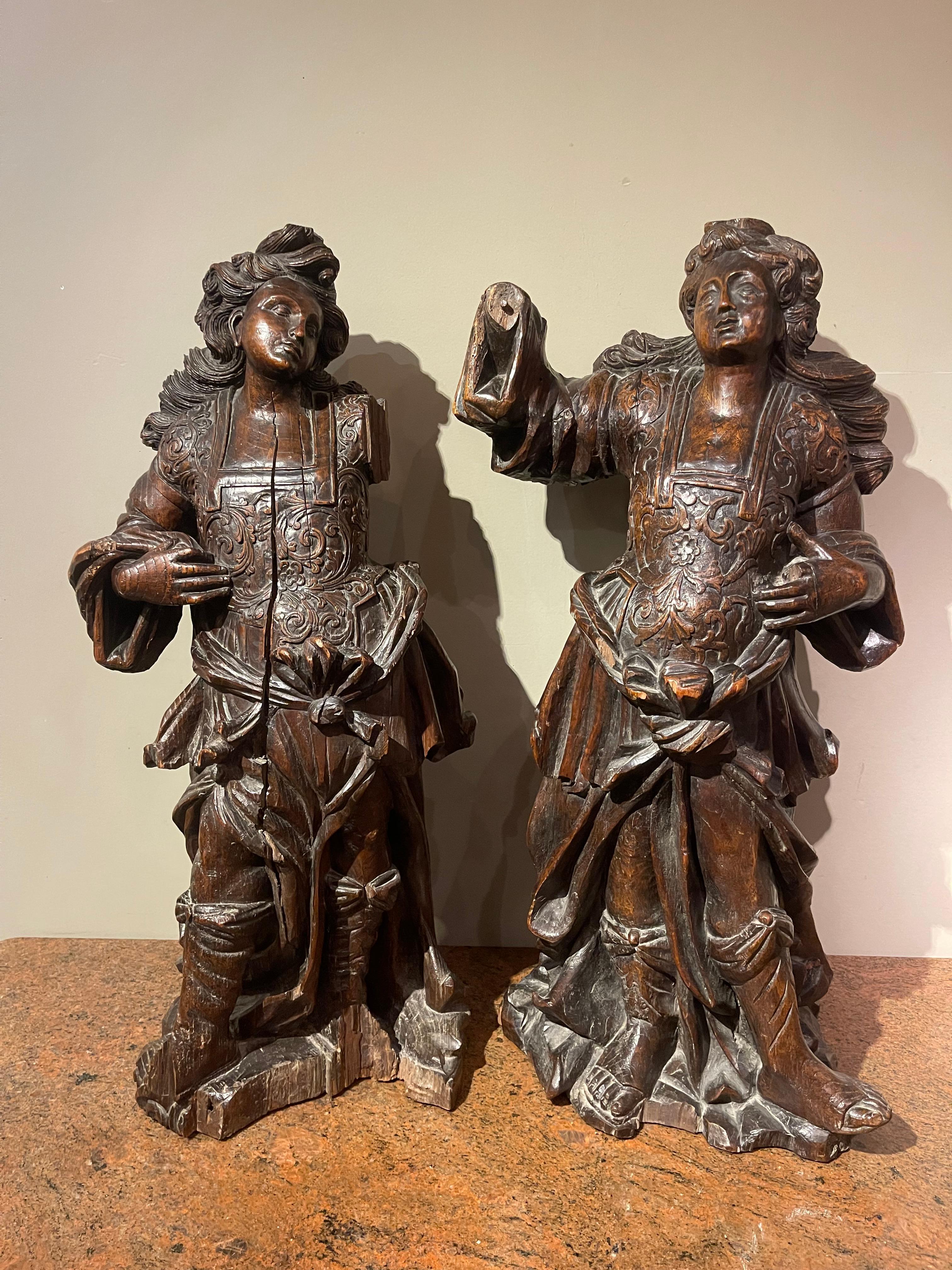Beautiful pair of cerulean angels sculpted in the round in a very lively position (the movement in the hair is remarkable), almost baroque. 
Very nice execution of the armour in the breastplate, with some visible missing parts, but very expressive.