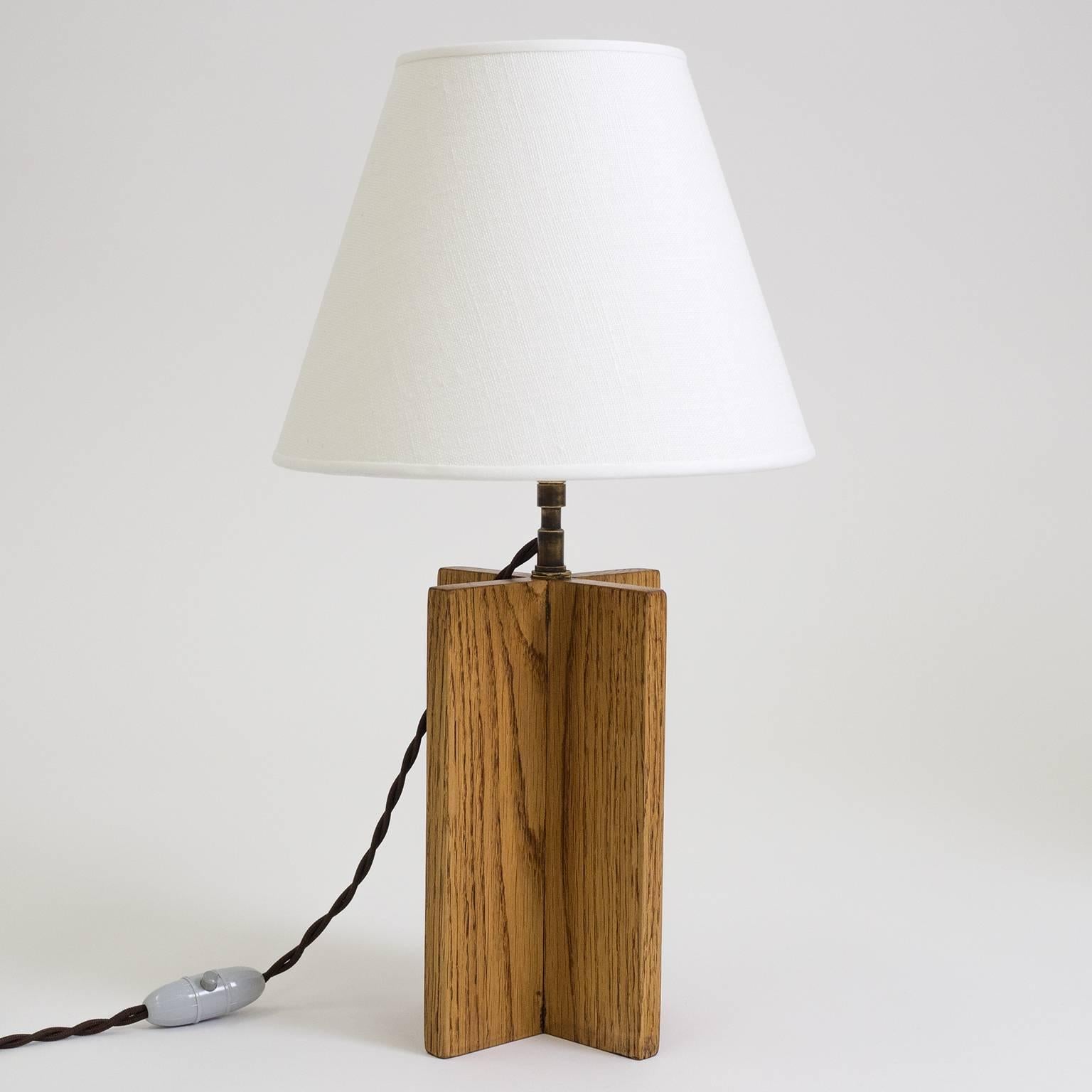 Nice pair of vintage oak 'croisillon' table lamps after Jean-Michel Frank. Solid oak cross-shaped base with a short brass neck and new linen shades. There is one brass and ceramic E14 socket with new wiring.
Measures: Oak base is 7.9inches/20cm